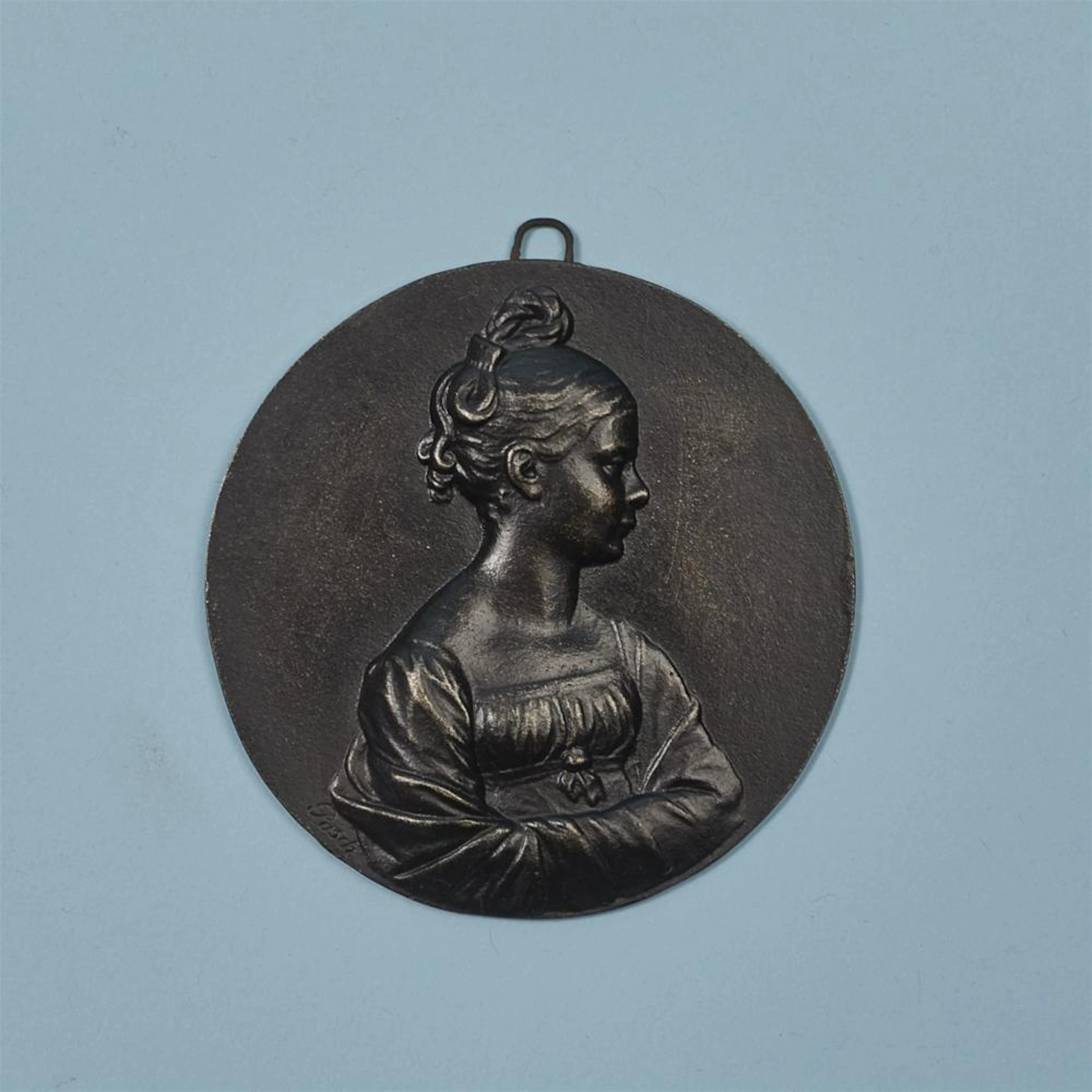 A round cast iron plaque with Princess Luise as a young girl