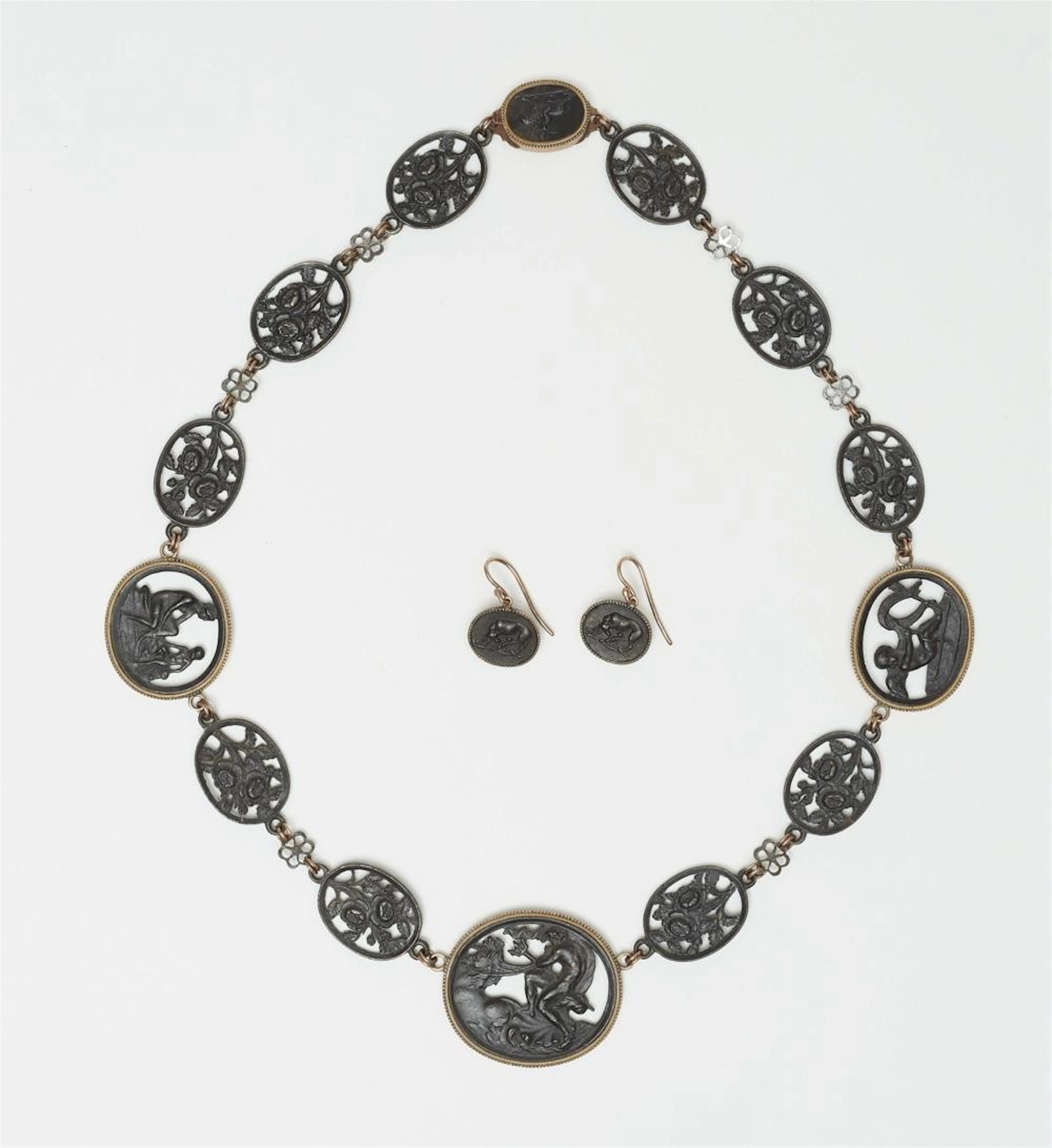 A cast iron demi-parure in the original case
