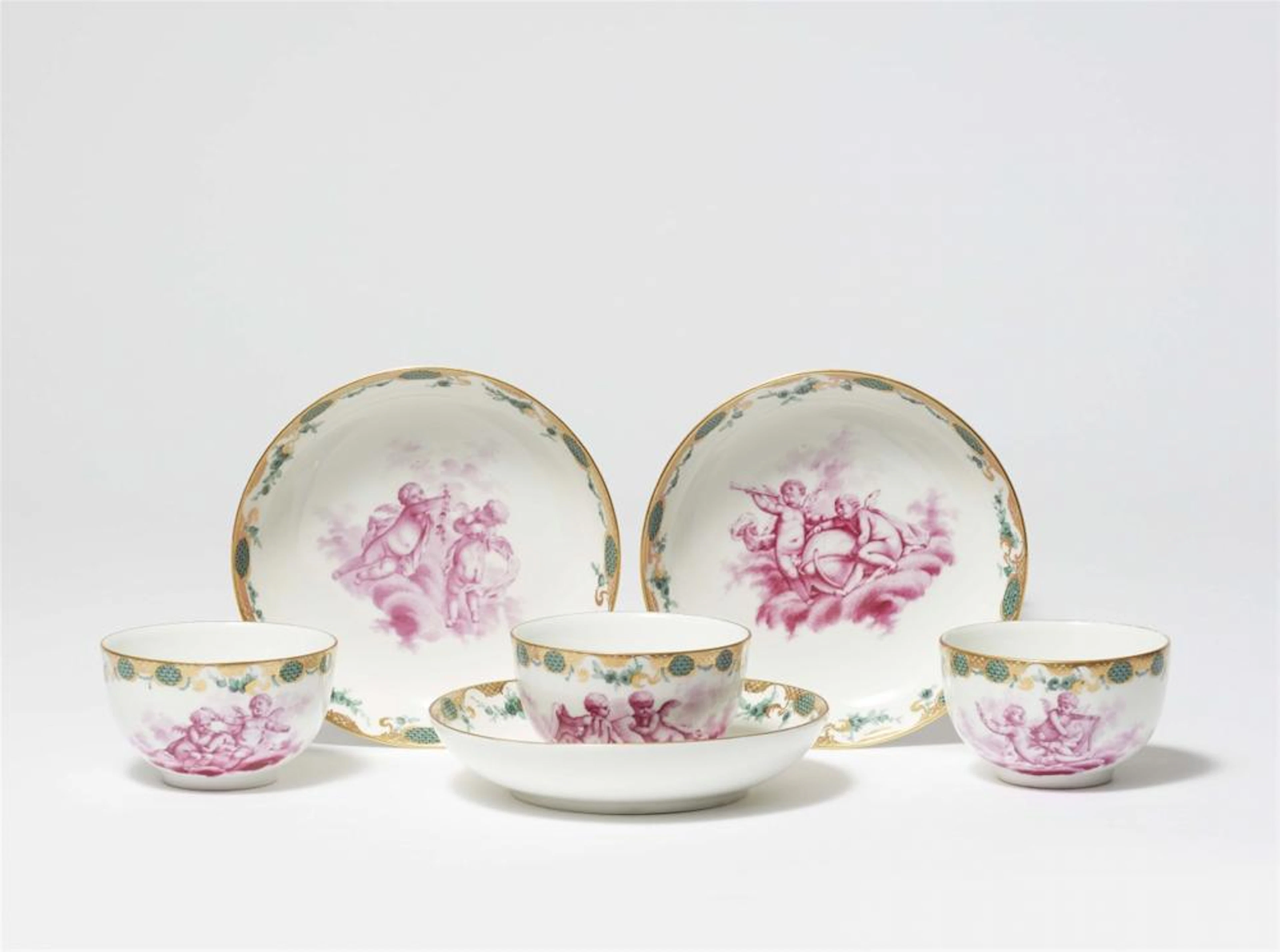 Three Berlin KPM porcelain cups and saucers with amoretti
