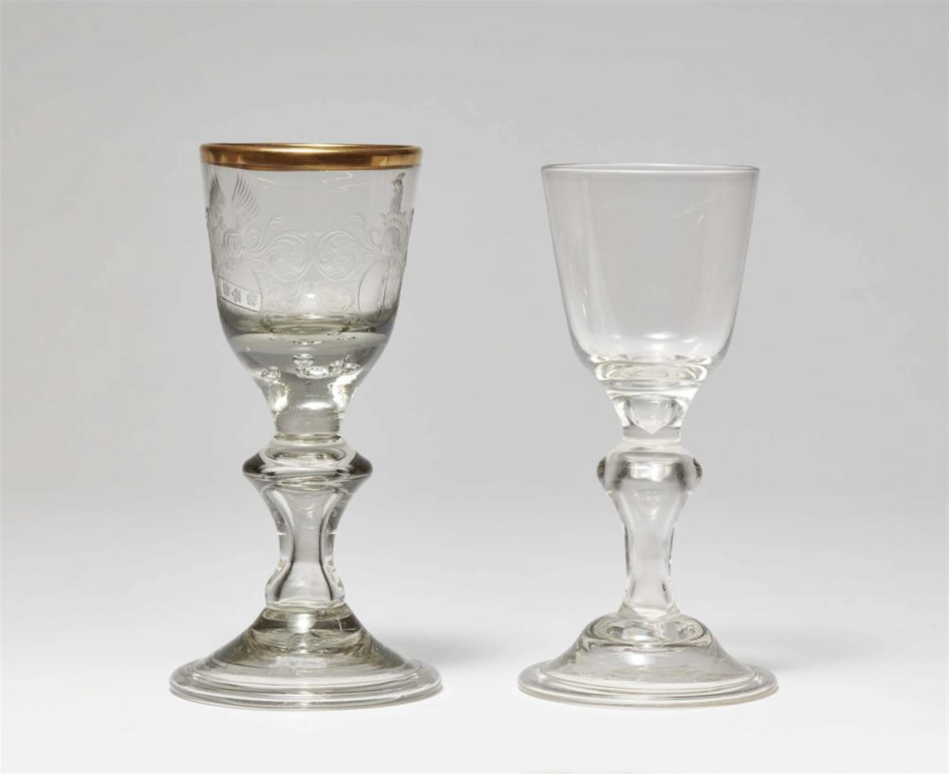 A cut glass goblet with two coats-of-arms