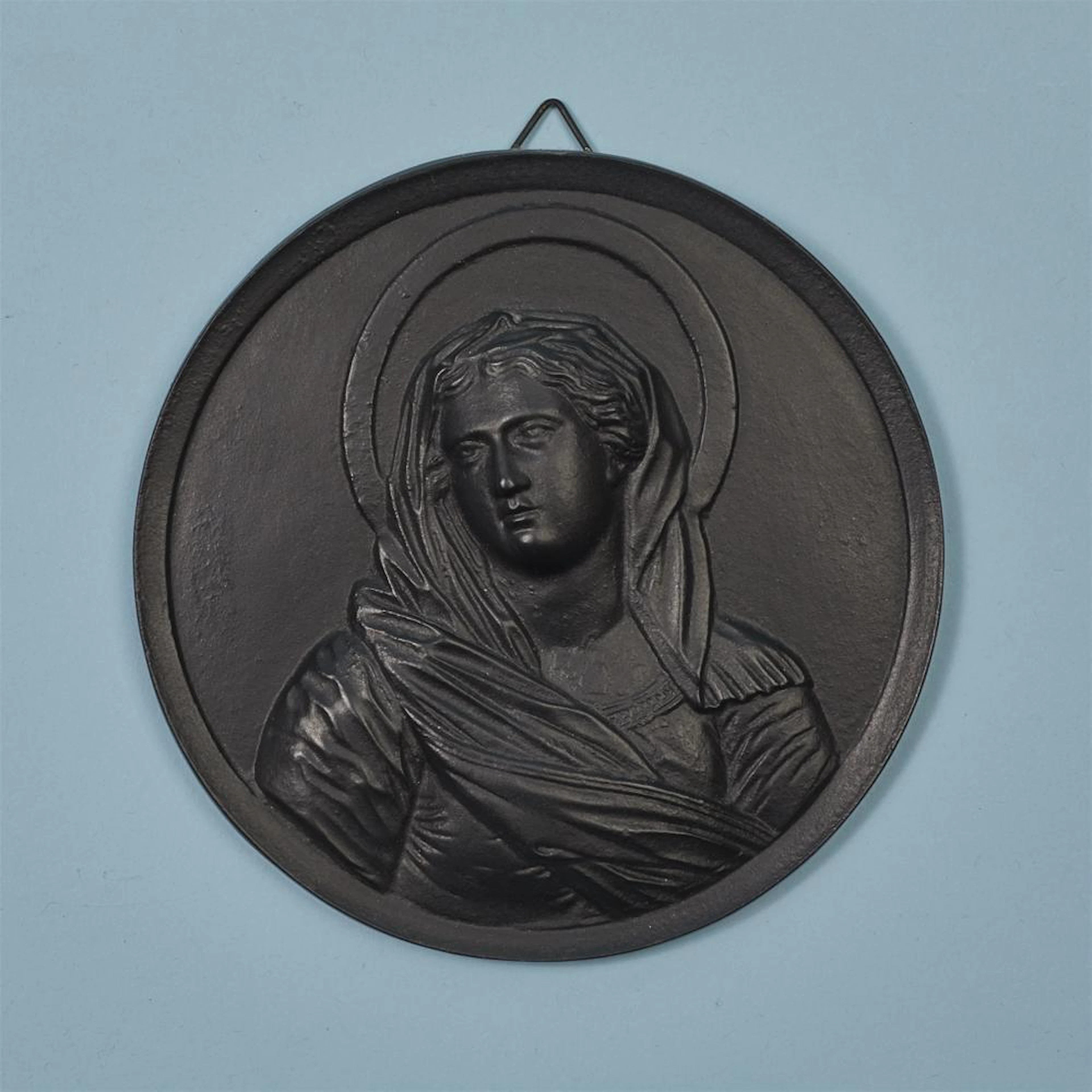 A cast iron plaque with the Virgin Mary