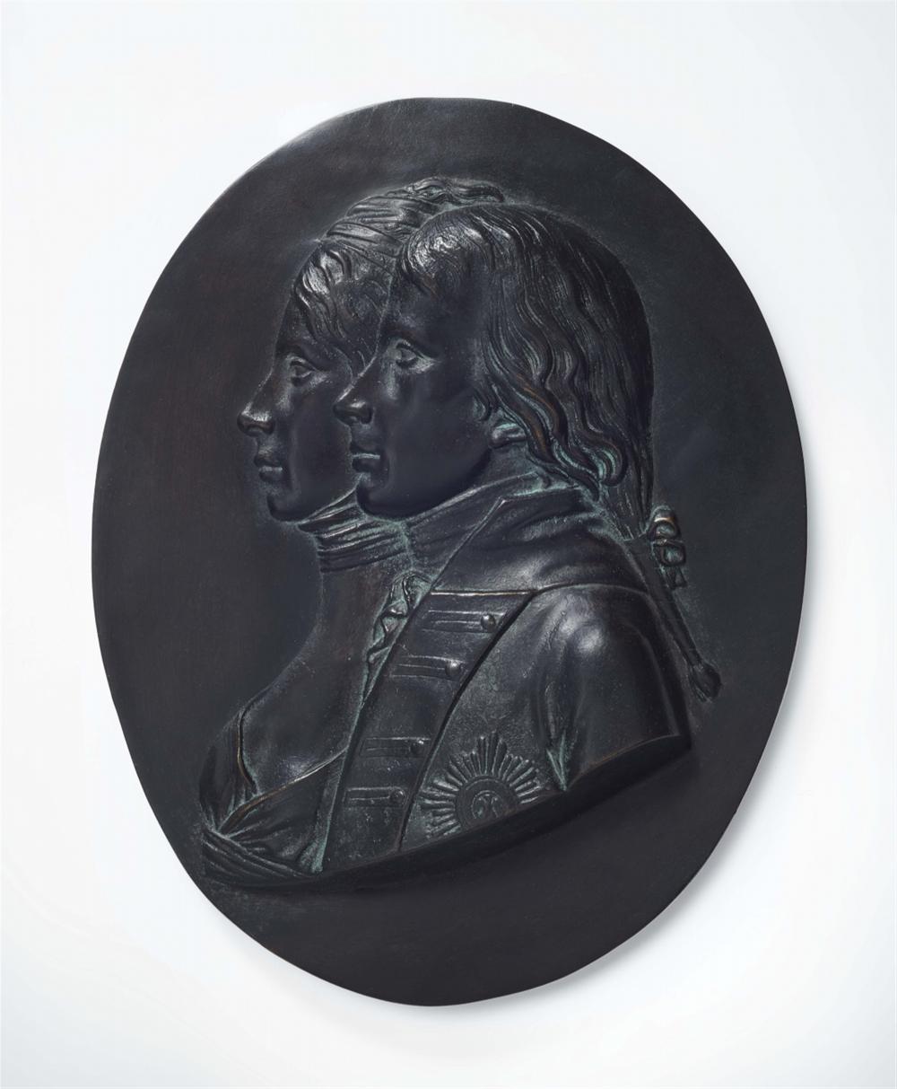 A cast iron medaillon with portraits of the royal couple