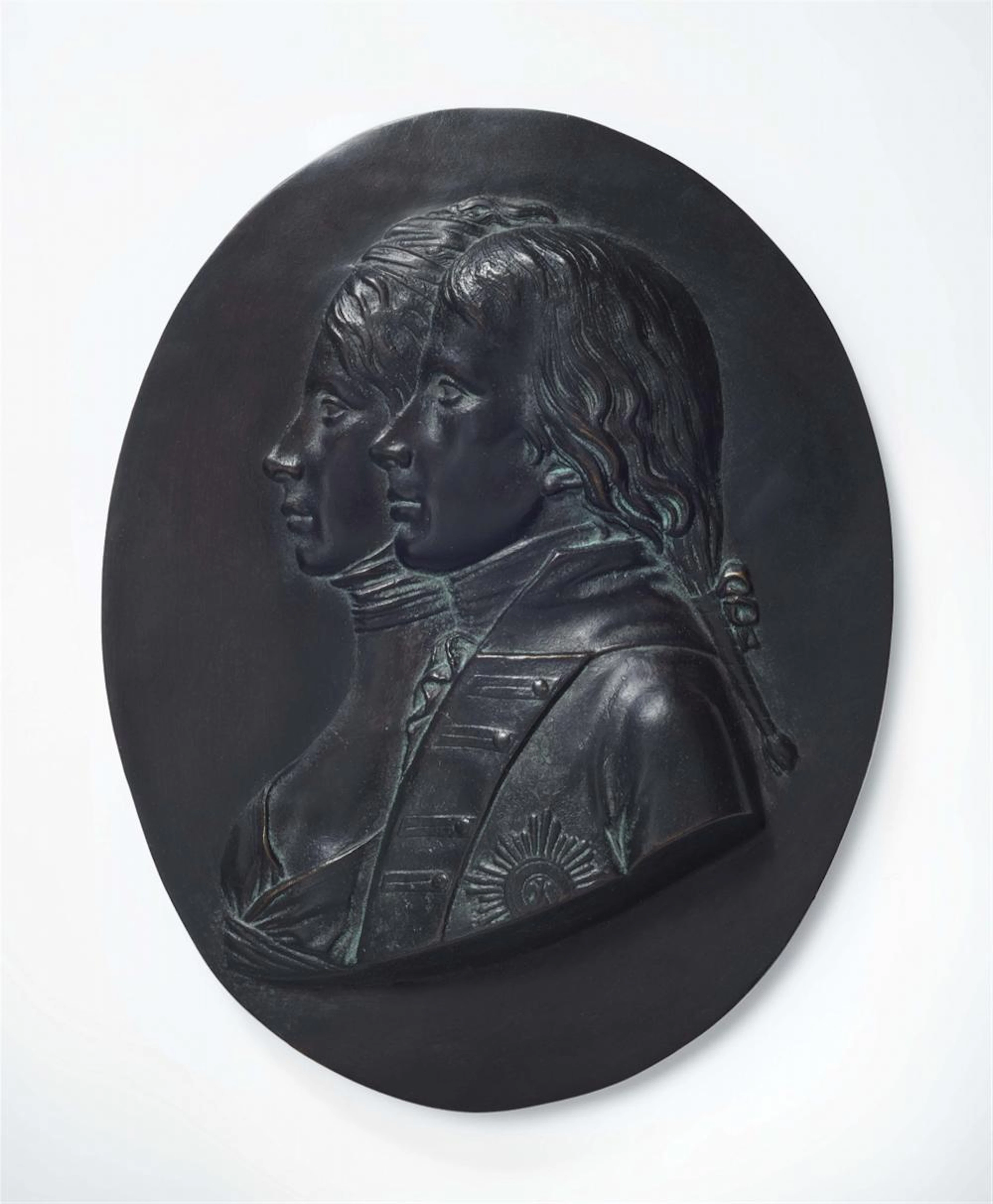 A cast iron medaillon with portraits of the royal couple