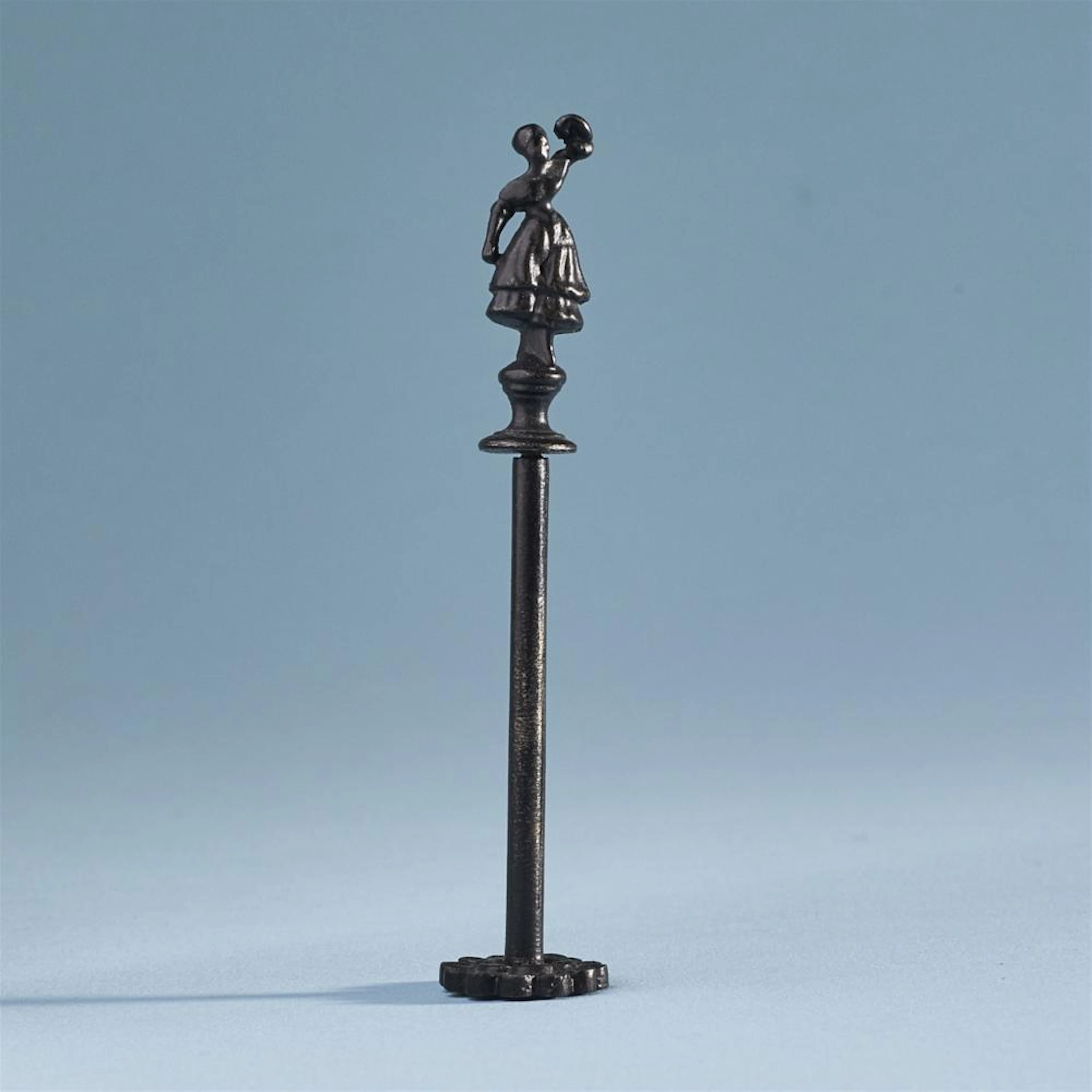 A cast iron pipe tamper with a figure of the dancer Fanny Elßler