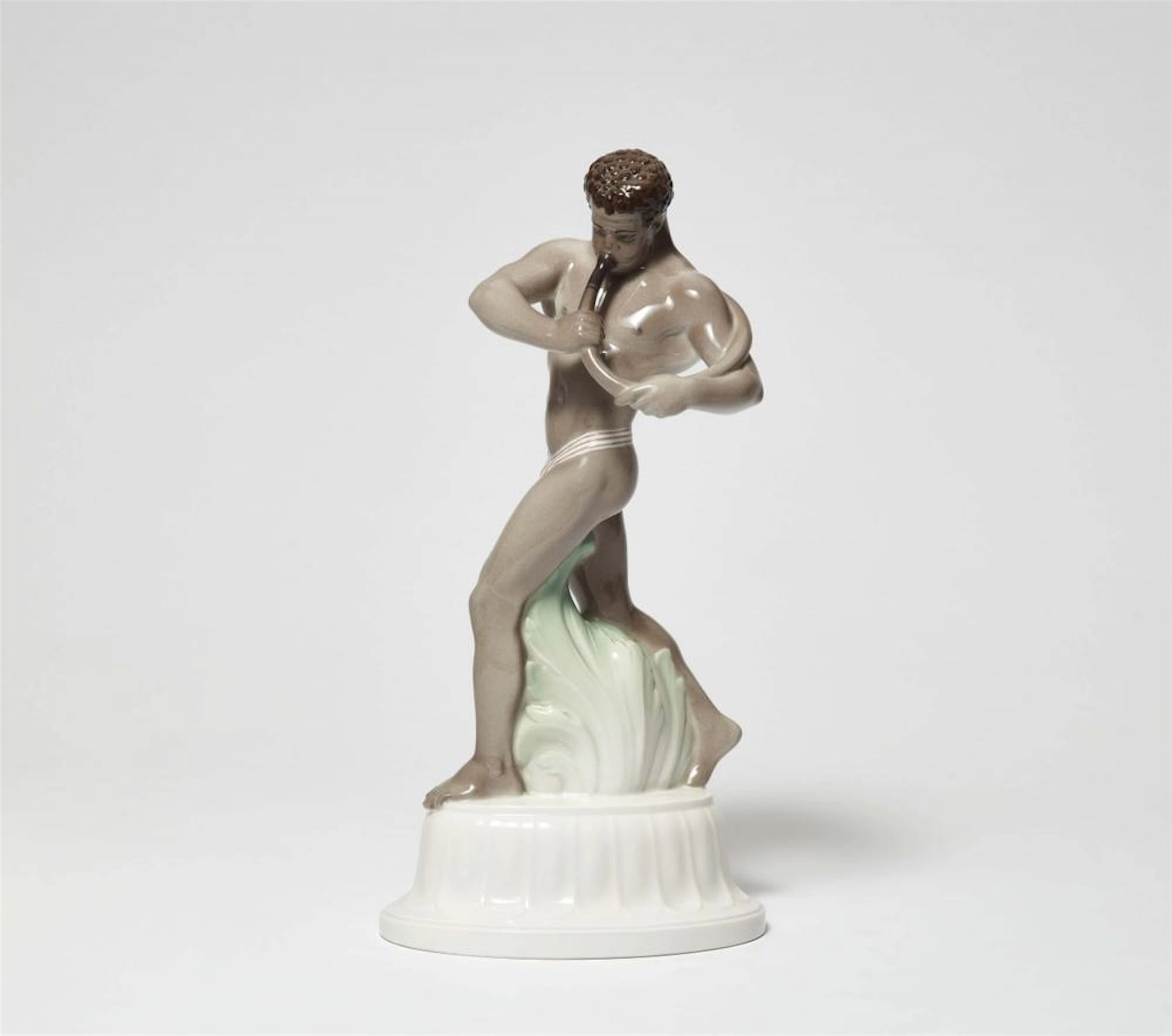 A Berlin KPM porcelain figure of an African man with a horn from Amberg's table centrepiece