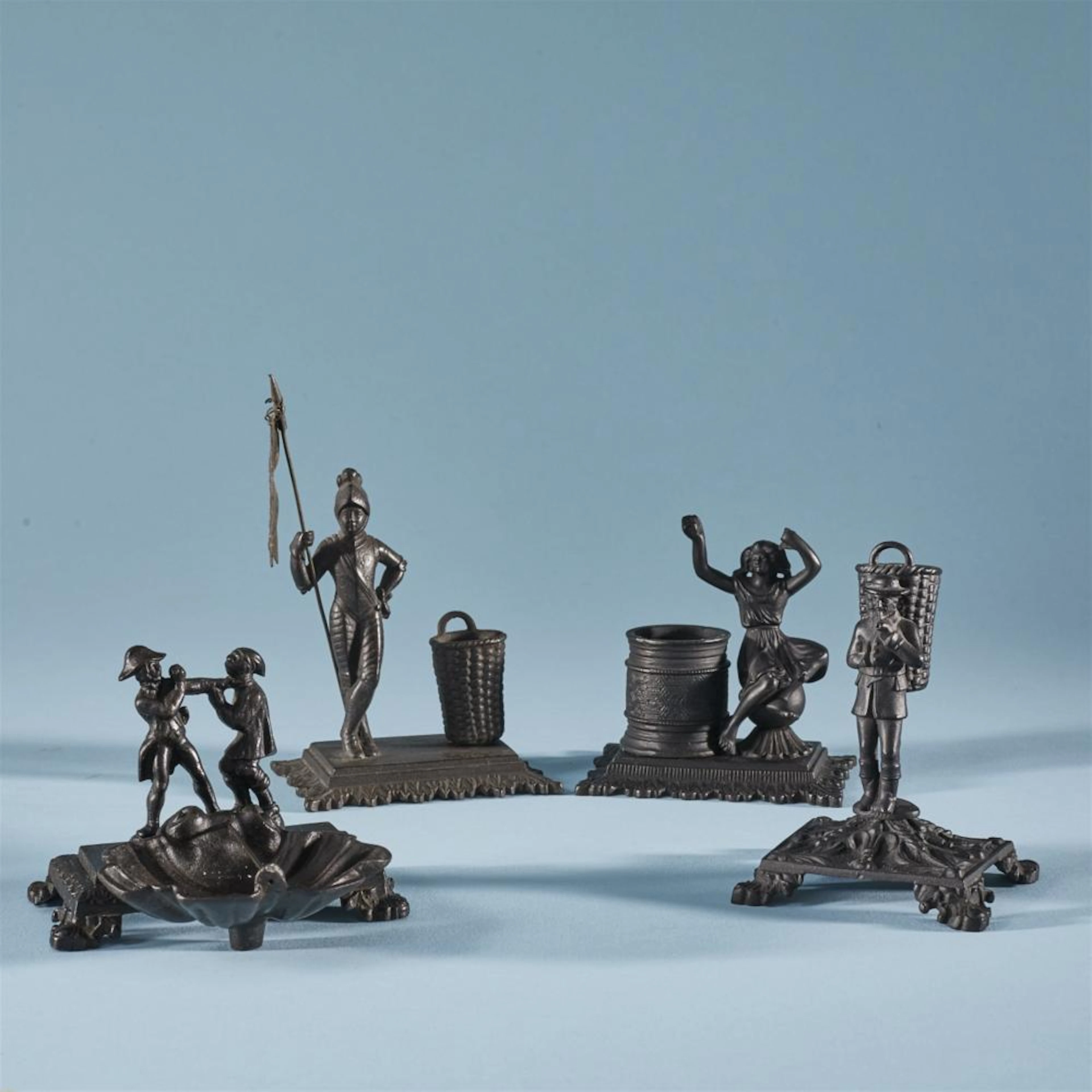 Four small cast iron table accessories