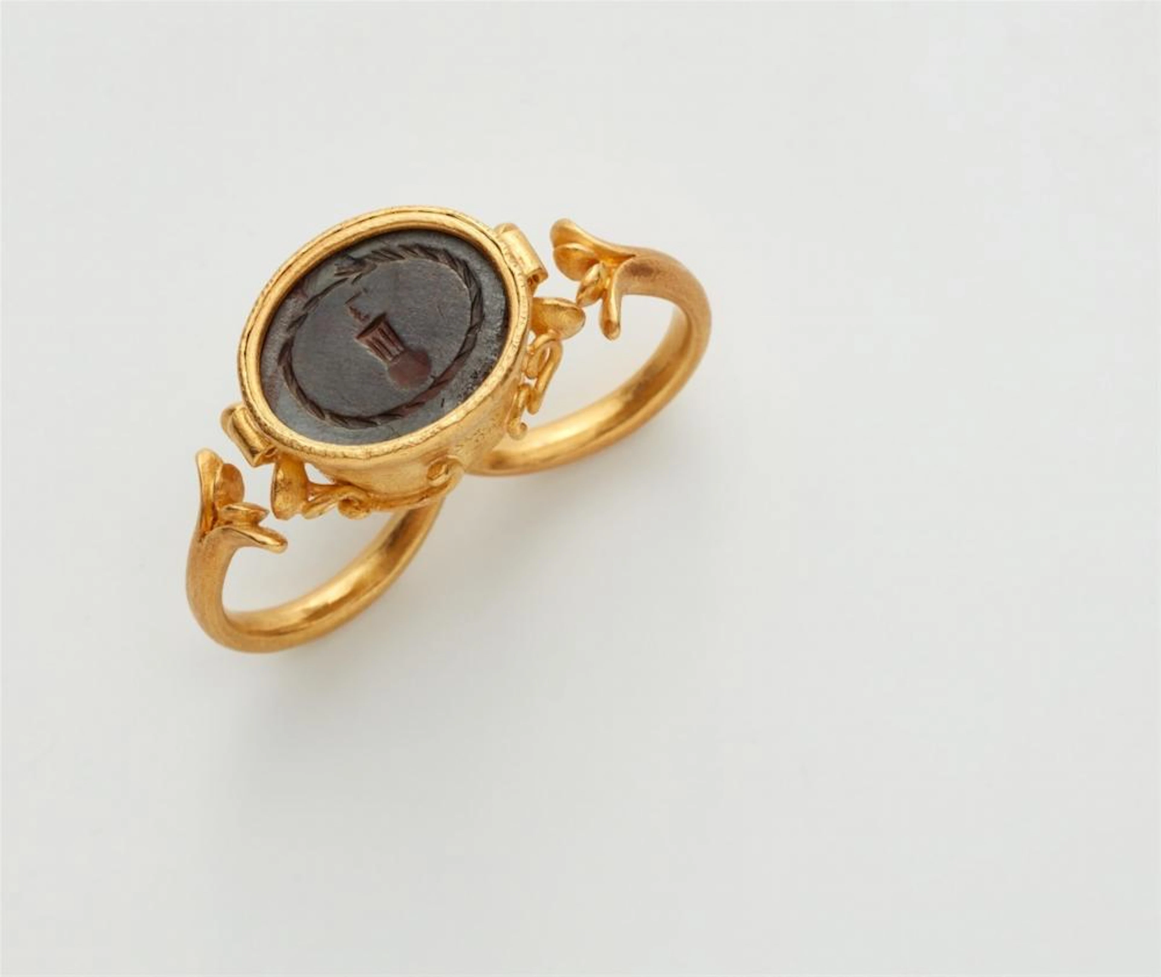 A 22k gold two-finger ring with a late Roman intaglio