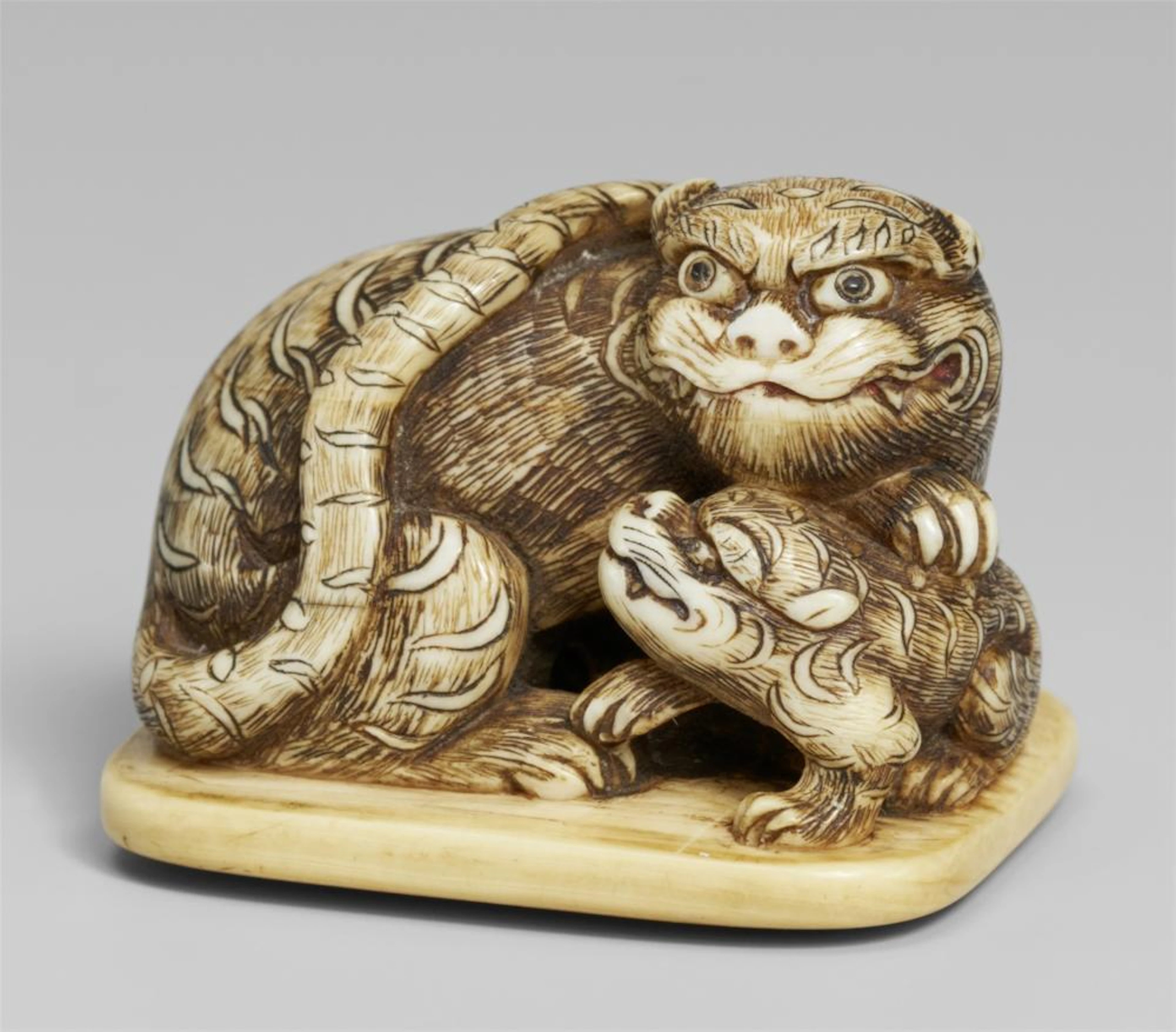 An ivory netsuke of a tiger and cub. Mid-19th century