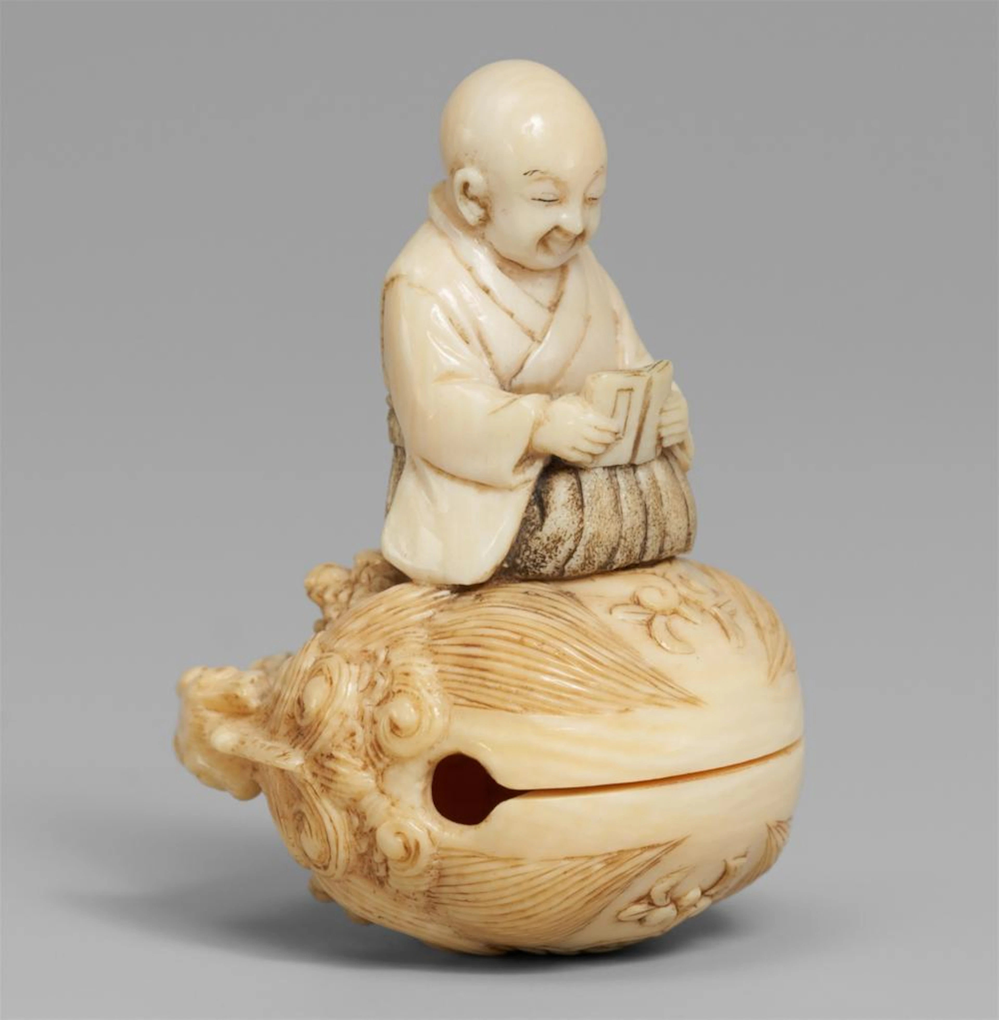 An ivory netsuke of a monk on a temple gong, by Kogyoku. Second half 19th century