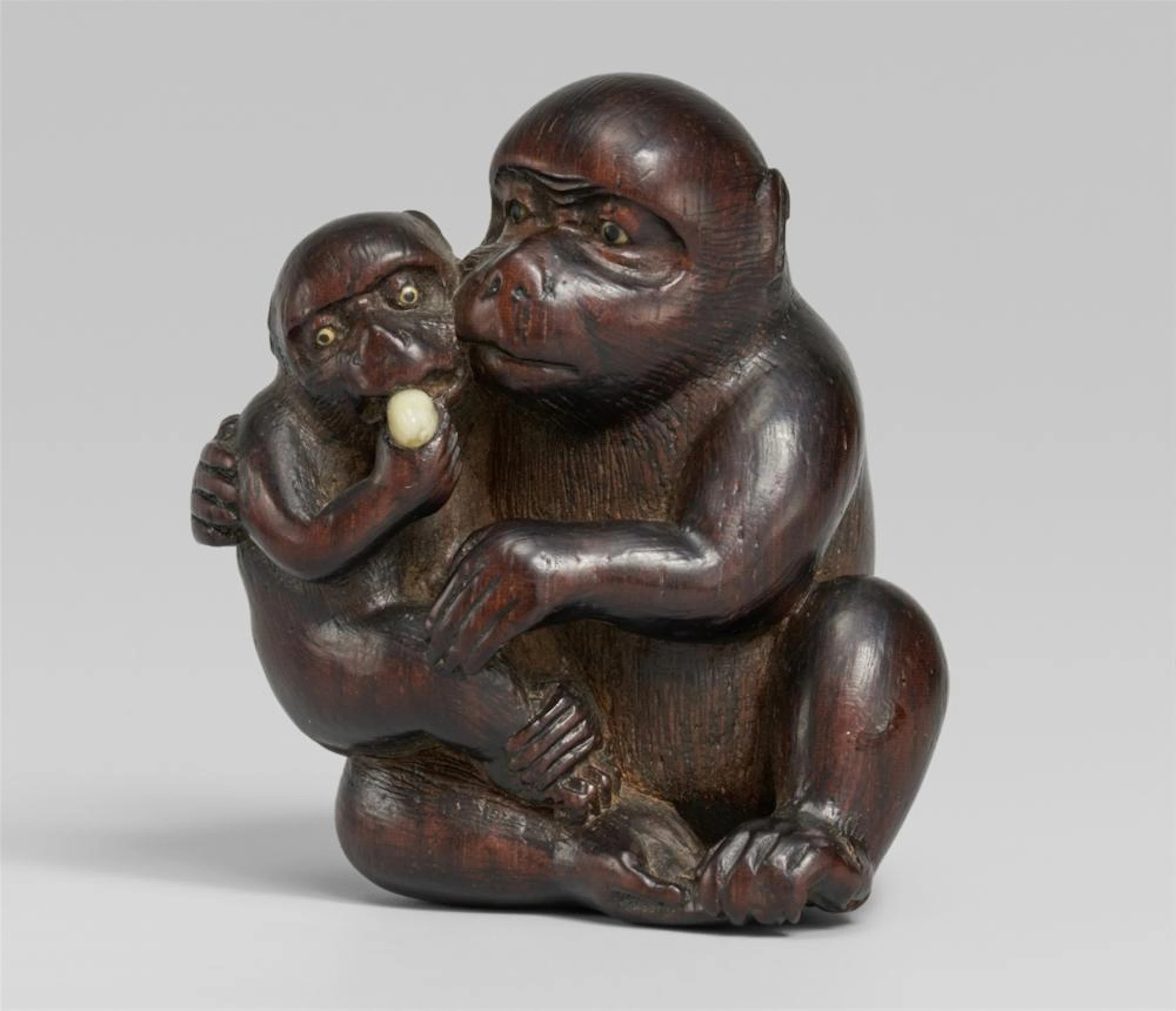 A reddish cherry wood netsuke of two monkeys, by Hidechika. Mid-19th century
