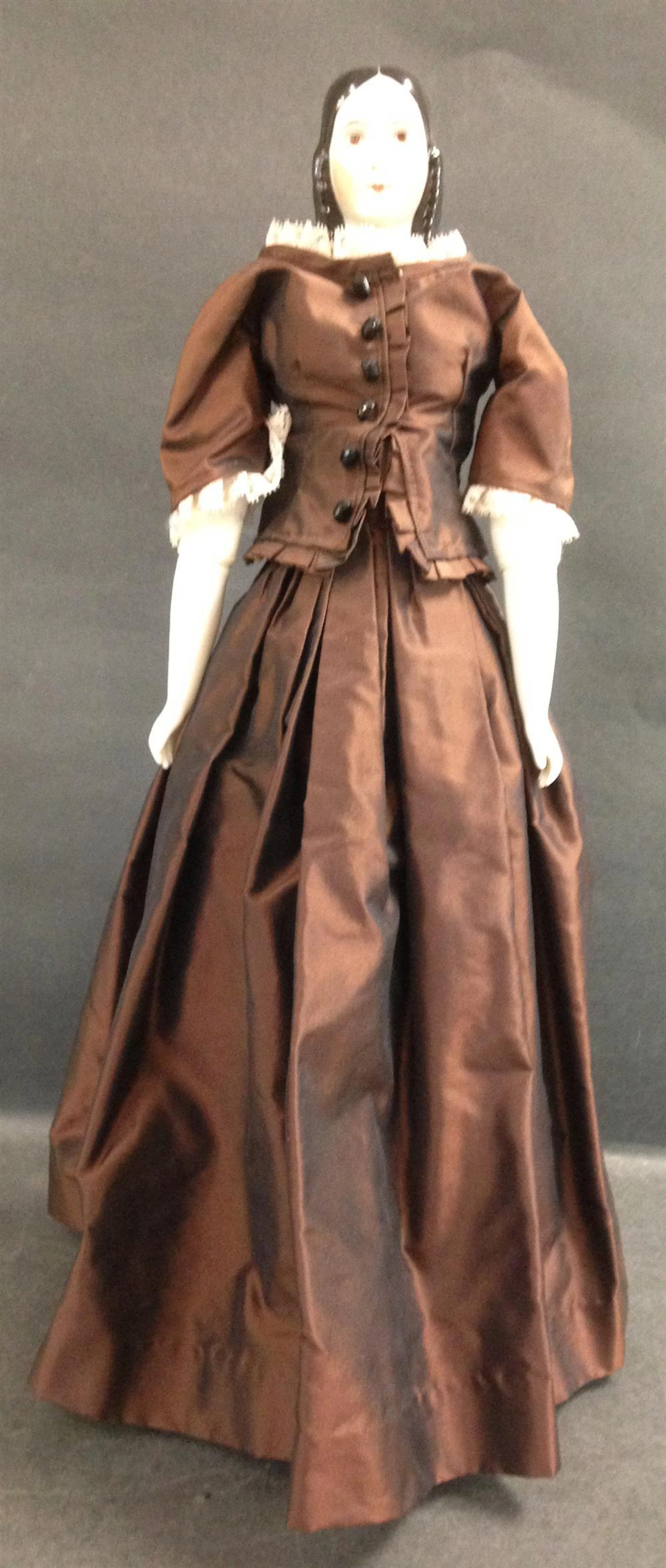 21" REPRODUCTION "LYDIA" CHINA HEAD DOLL WITH BROWN EYES AND MOLDED BREASTS ON CLOTH BODY WITH CHINA LOWER ARMS AND LEGS. WEARS DAR...