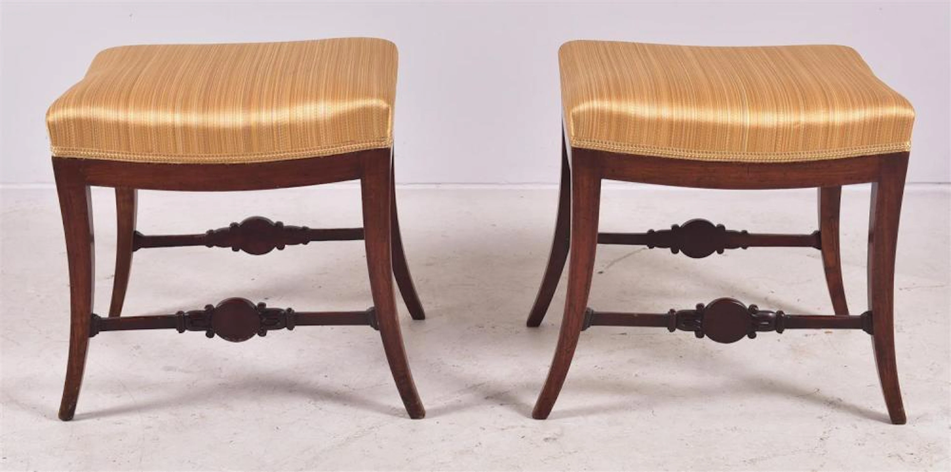 Pair Regency style mahogany foot stools with carved outside escutcheons