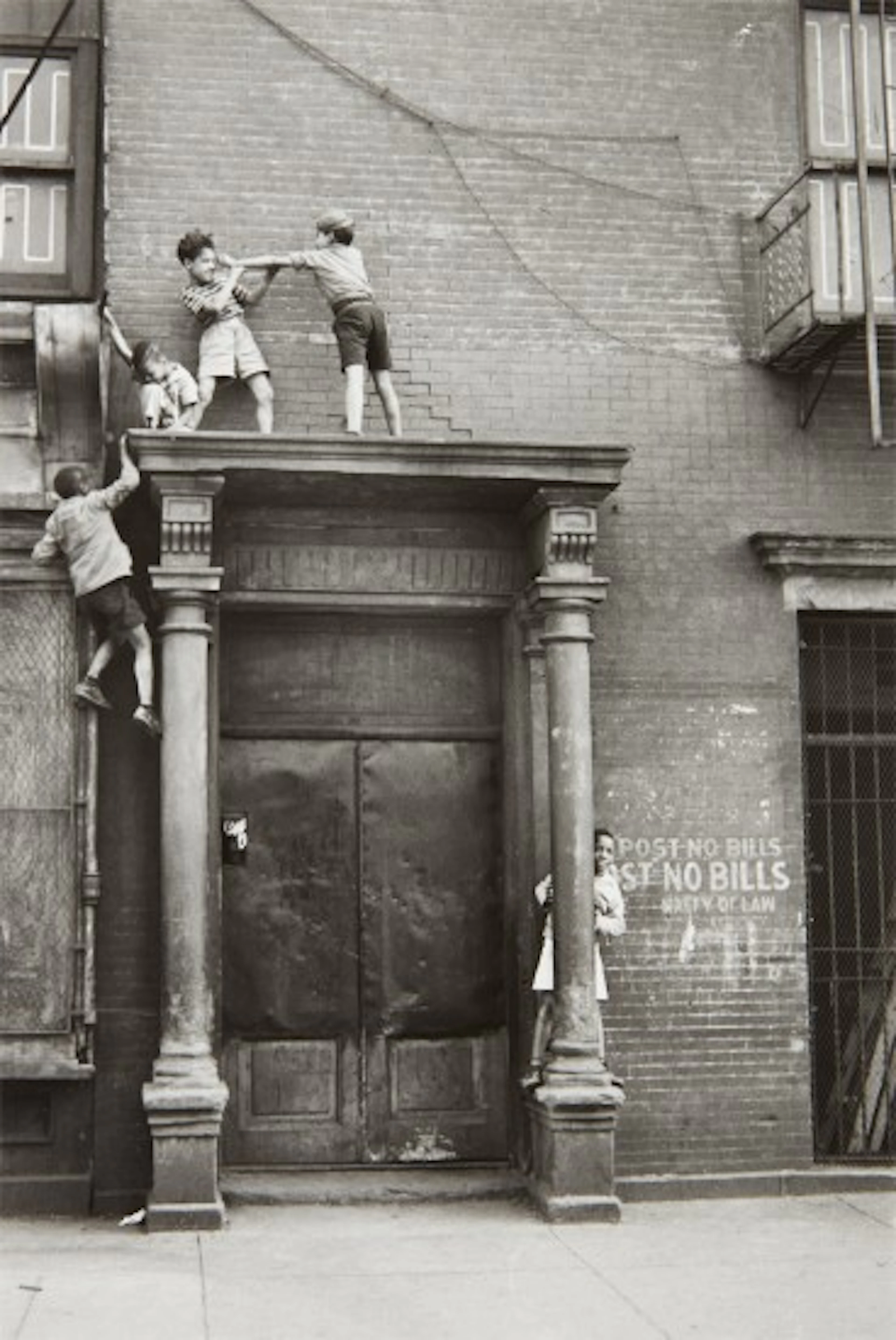 Helen Levitt - N.Y.C. (boys playing over doorway)