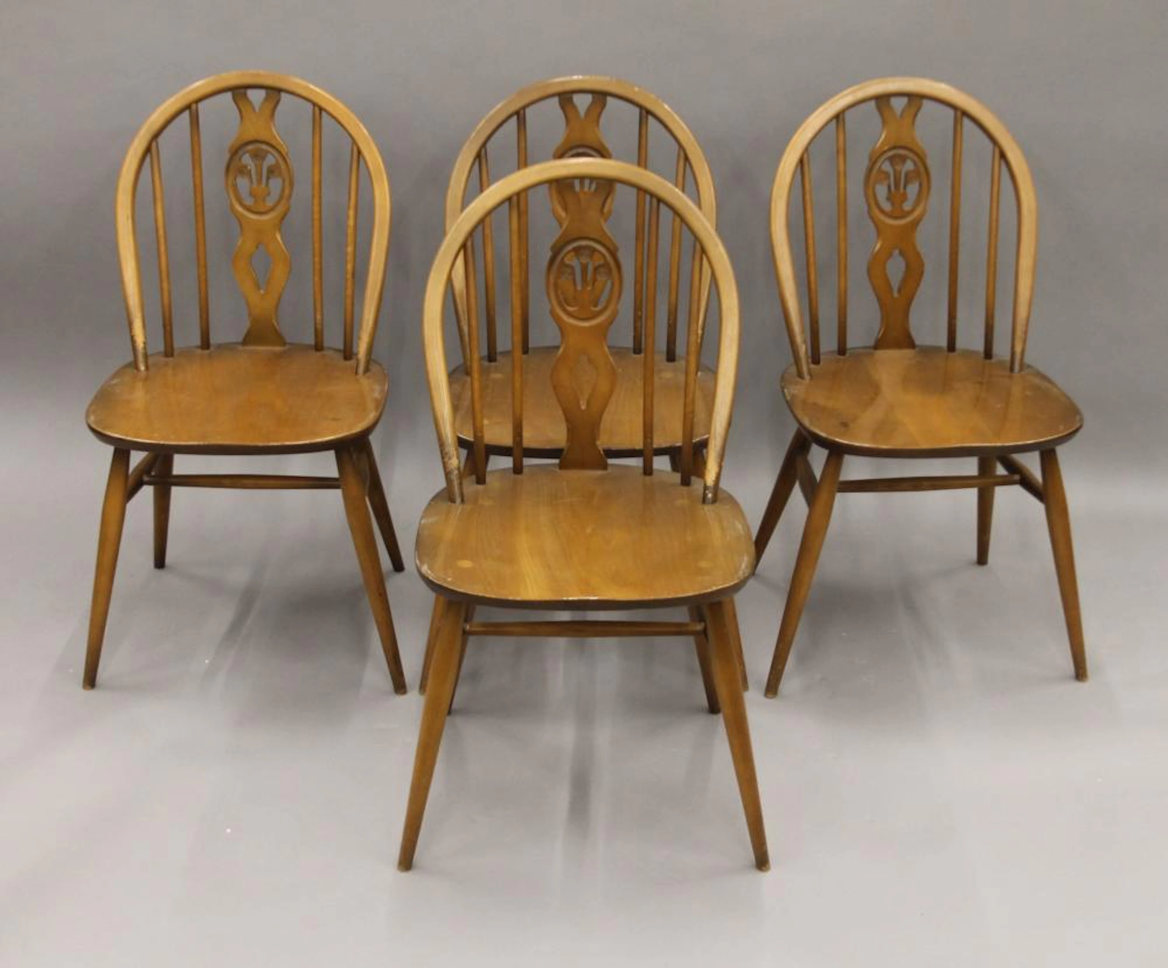Four Ercol dining chairs.