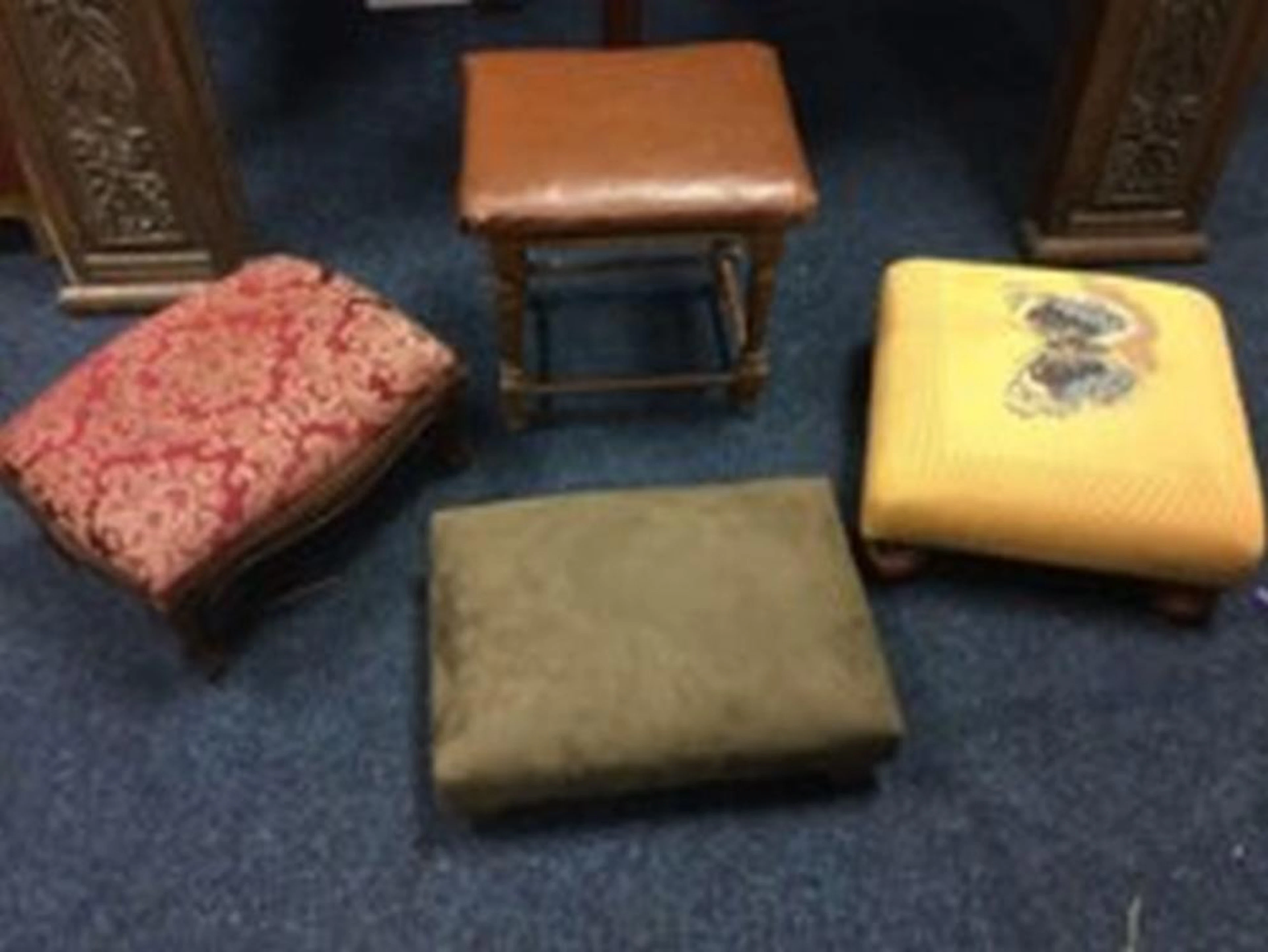 A square footstool with butterfly tapestry style upholstery on turned legs