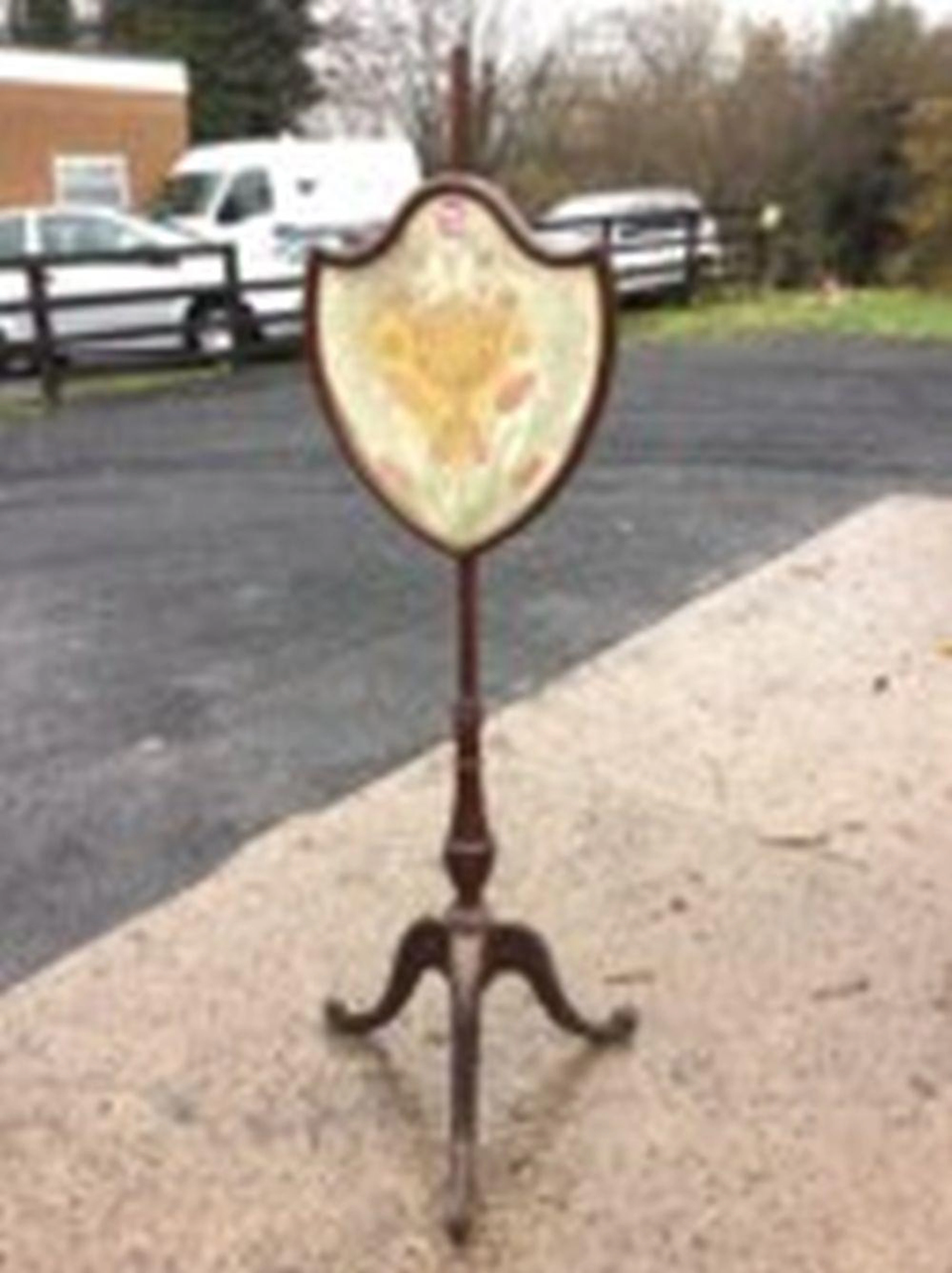 A Victorian mahogany firescreen, the shield shaped glazed floral crewelwor