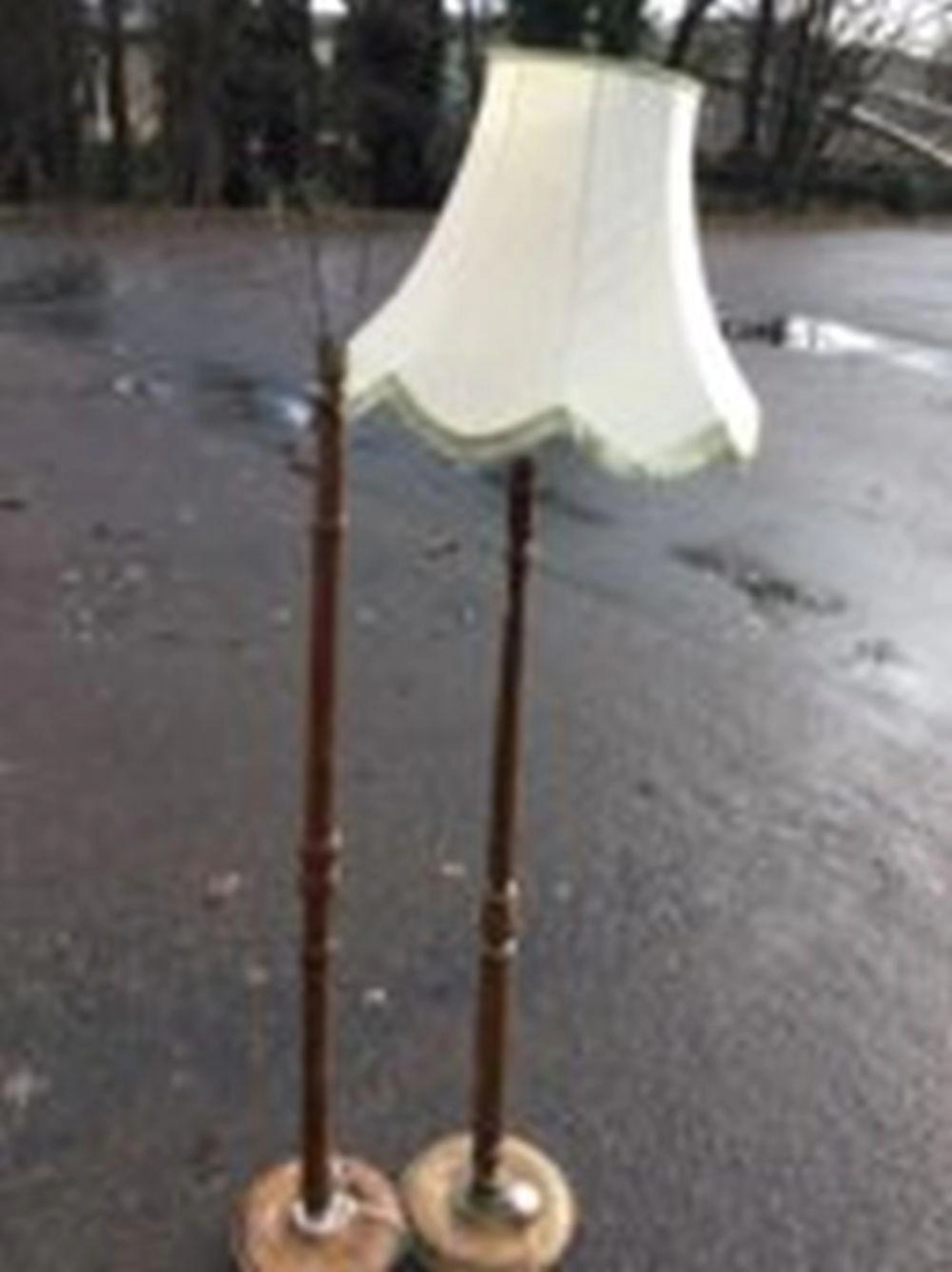 A walnut standard lamp with turned column on circular base; and another wit