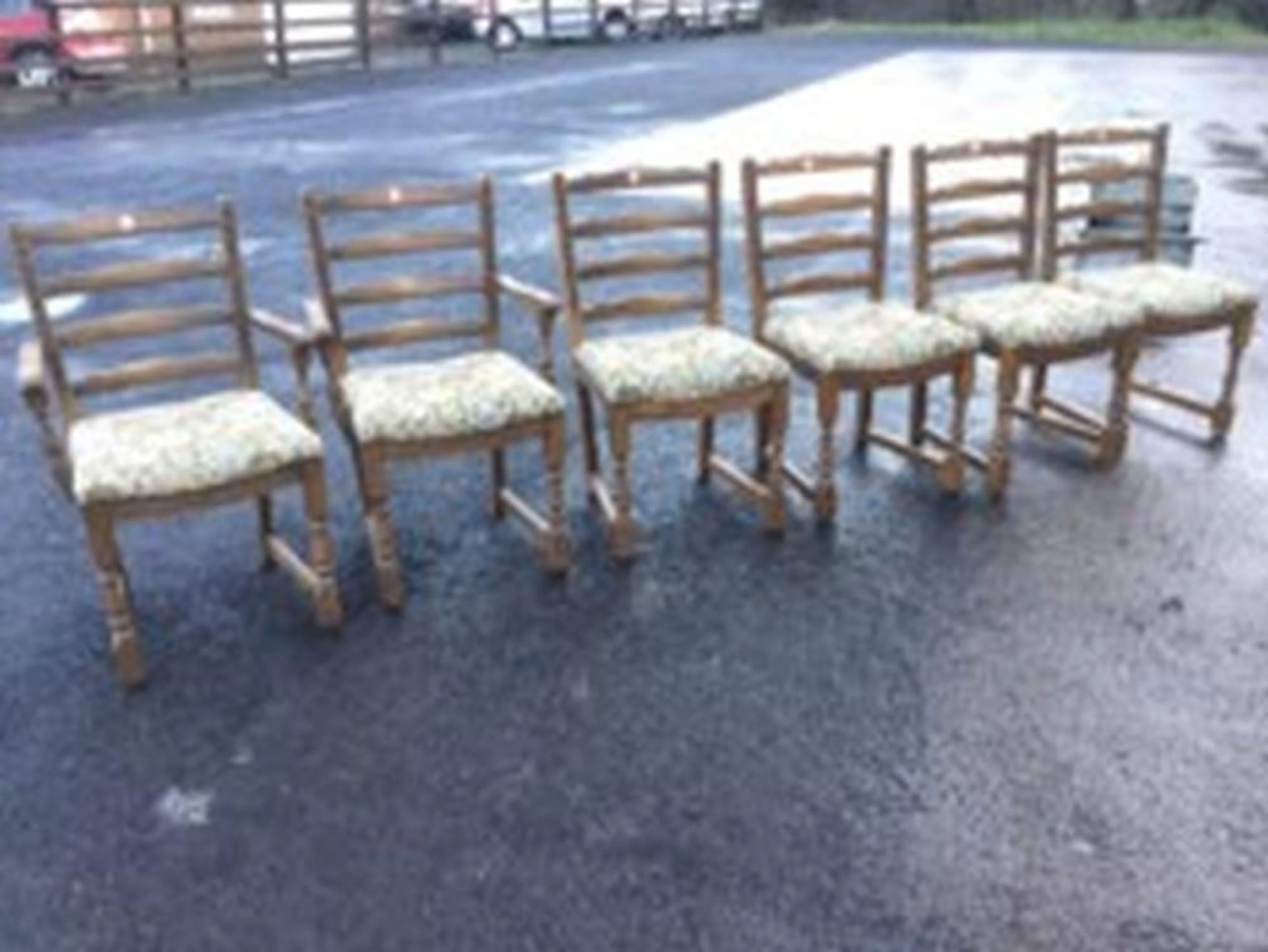 A set of six oak ladderback dining chairs including two carvers, having chi