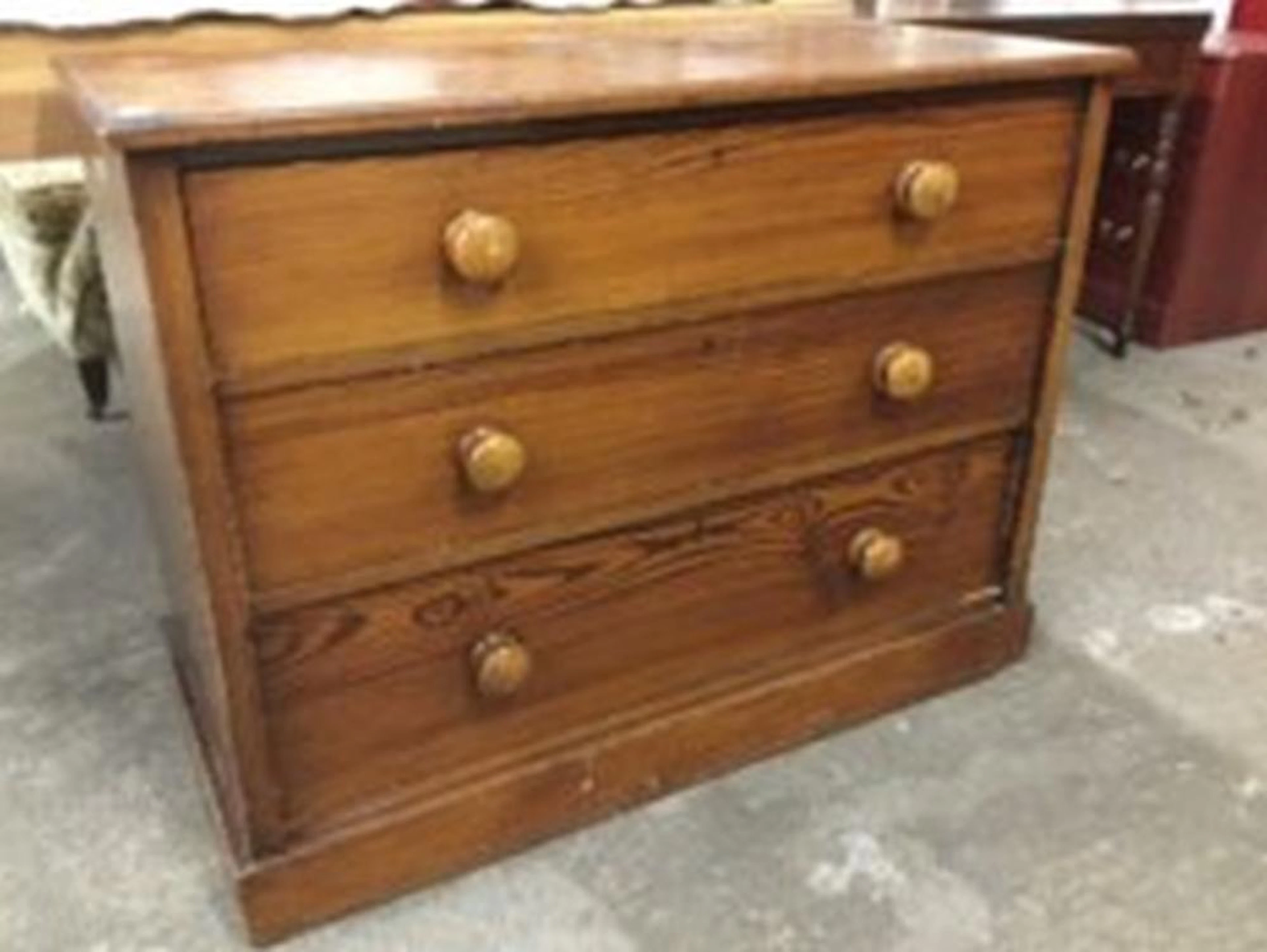 A Victorian pitch pine chest of three long knobbed drawers, supported on a