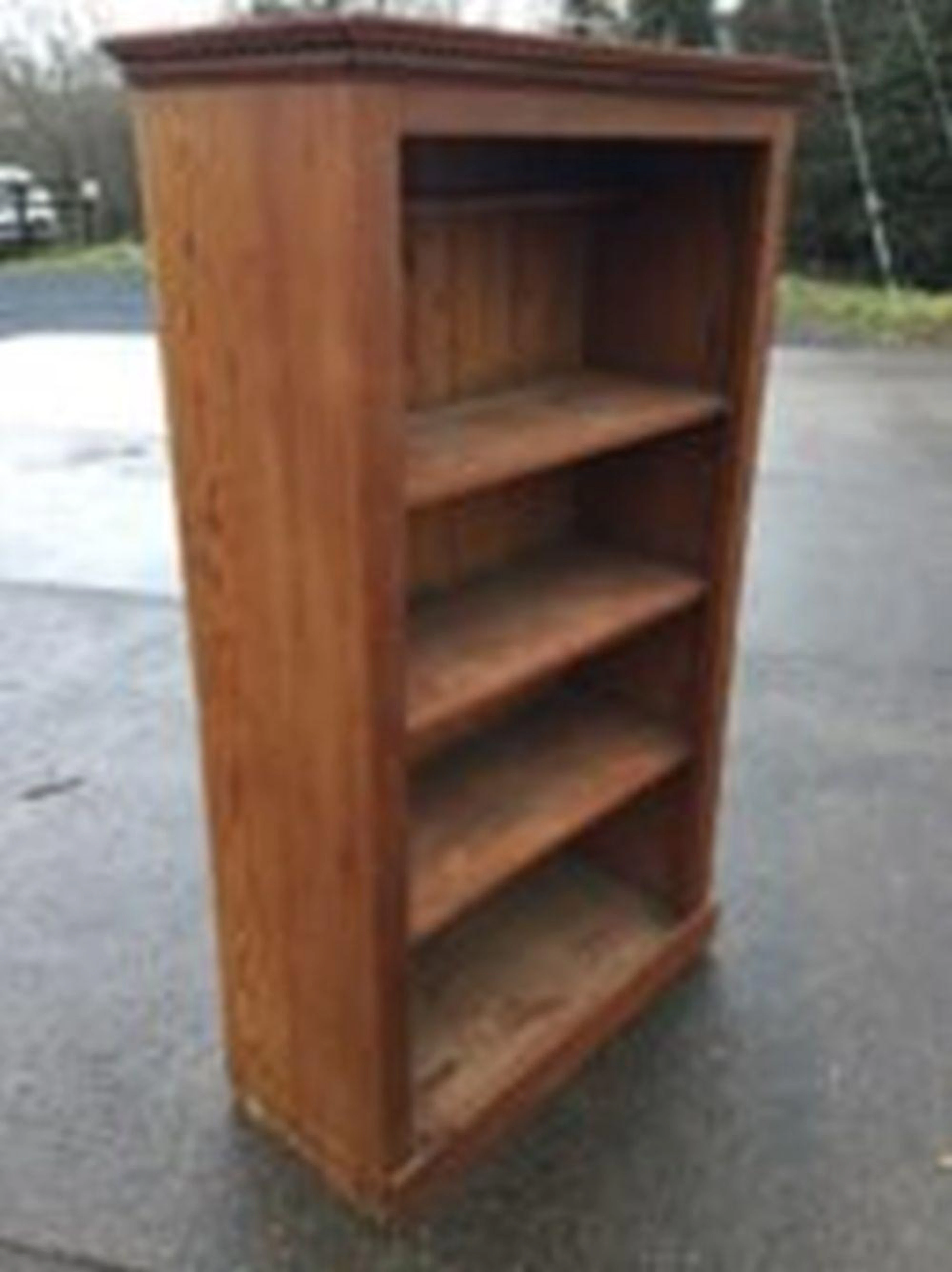 A pitch pine open bookcase with moulded cornice above shelves, having tong