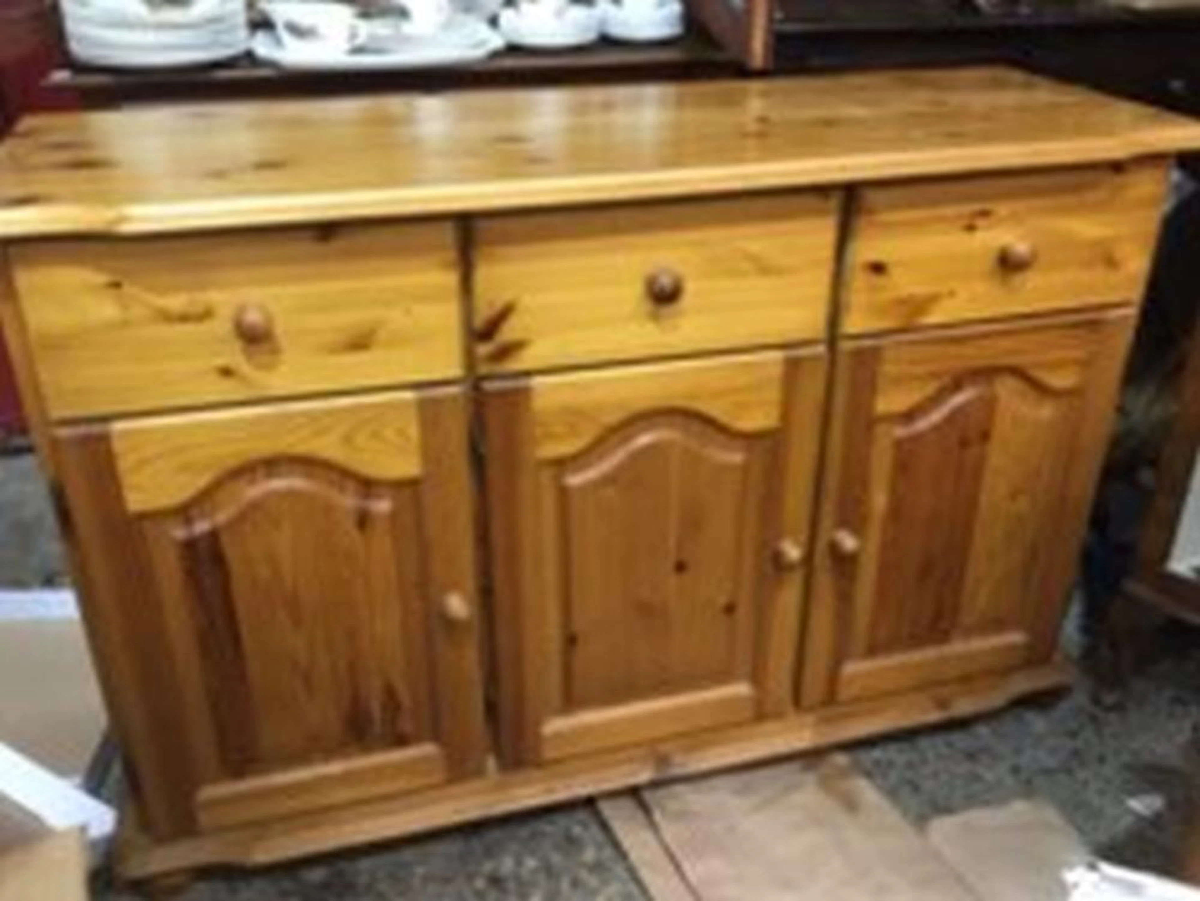 A pine dresser base with three frieze drawers above arched fielded panelled
