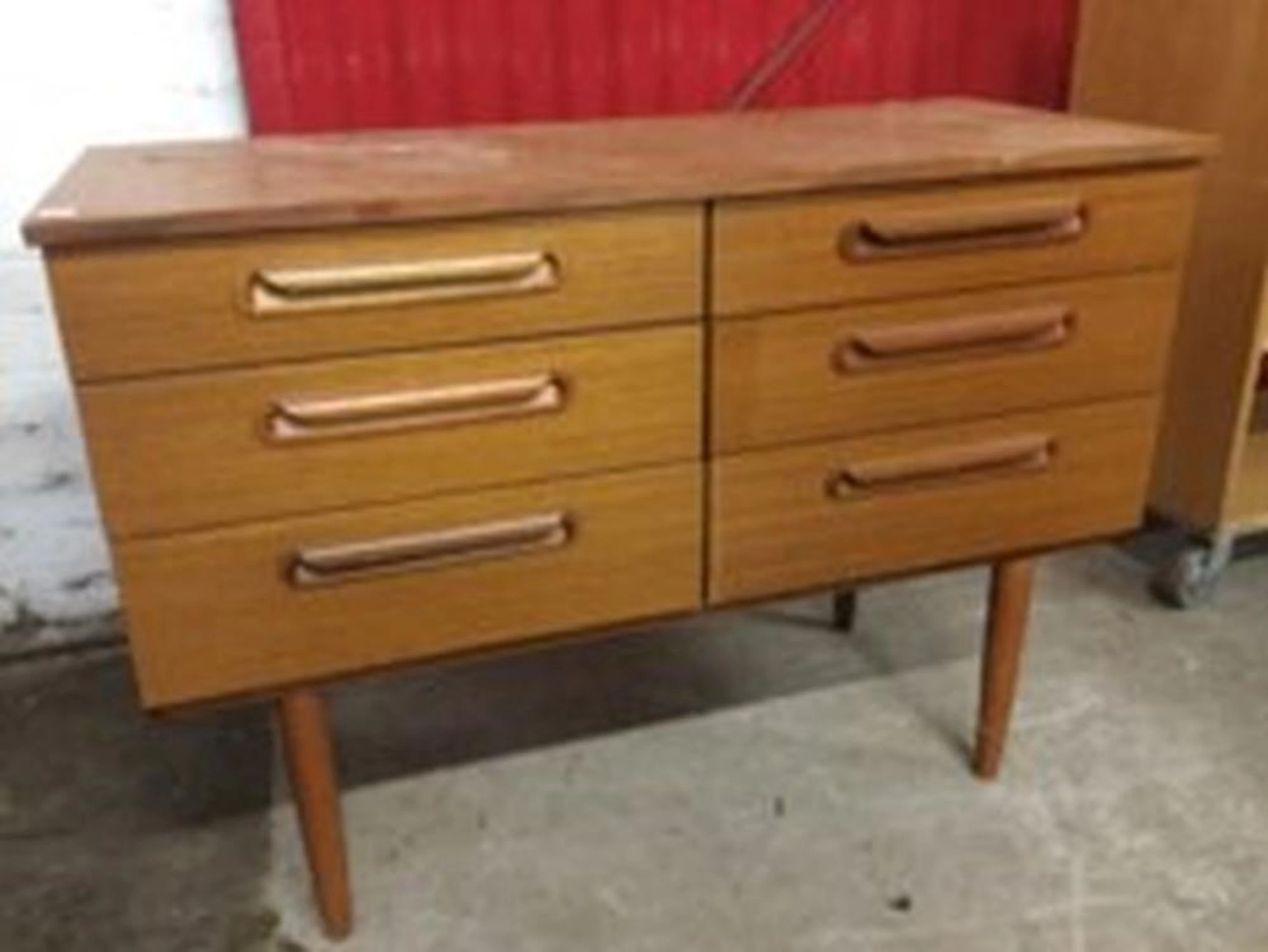 A 1960s Schreiber teak cabinet of six graduated drawers having rectangular