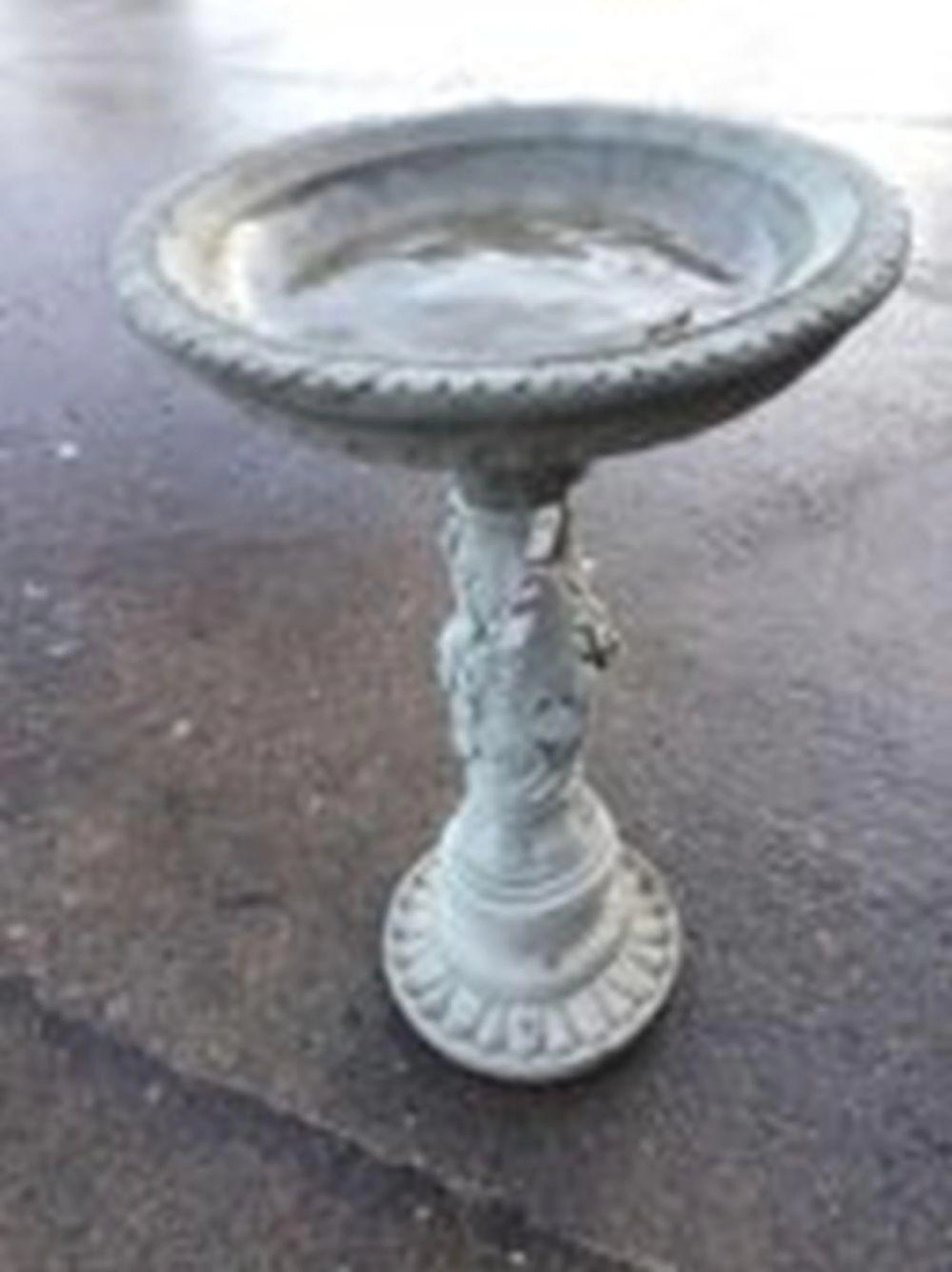 A composition stone birdbath, the circular bowl with leaf moulded rim supp