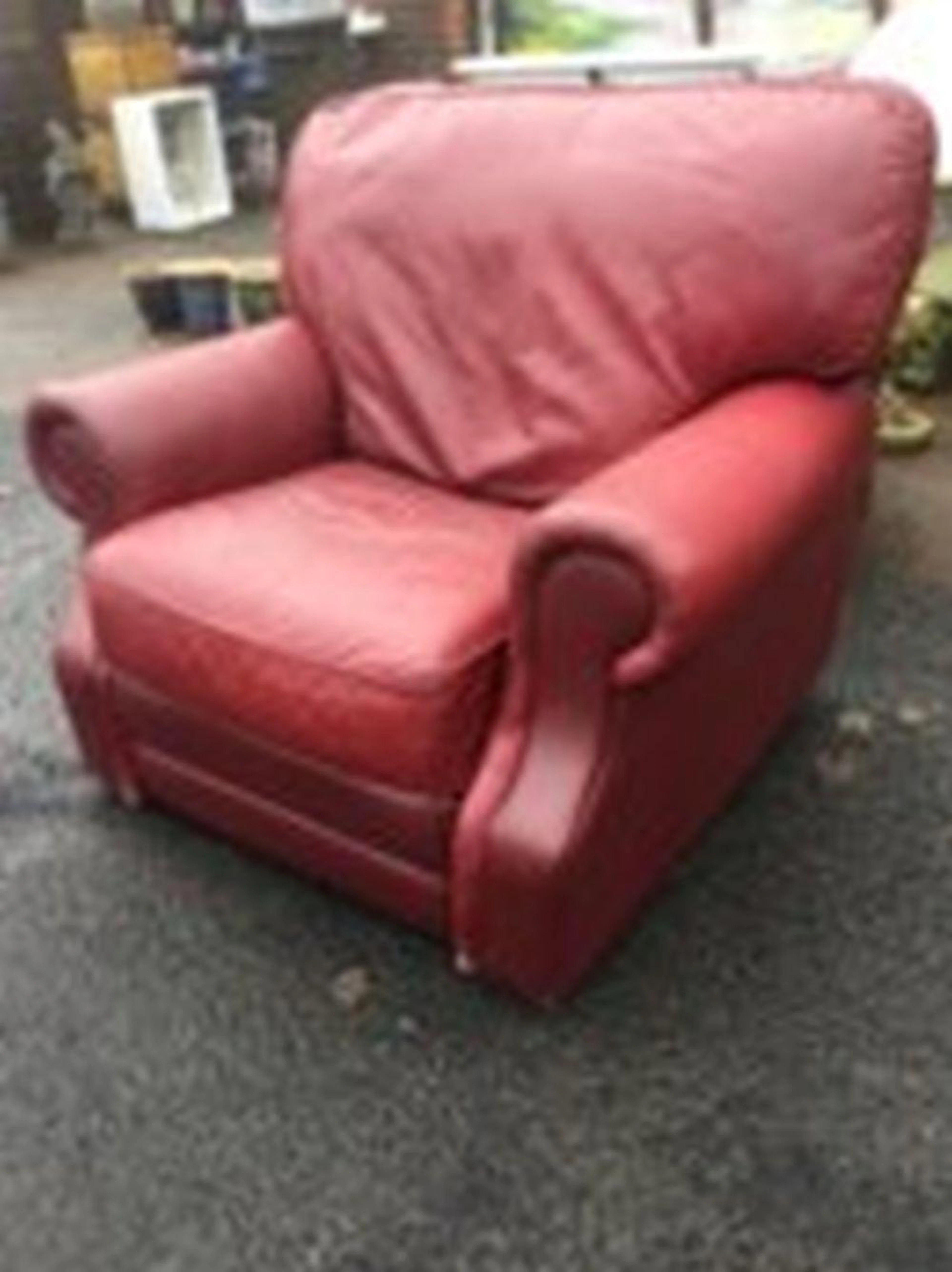 A large leather upholstered armchair with reclining mechanism, having integ