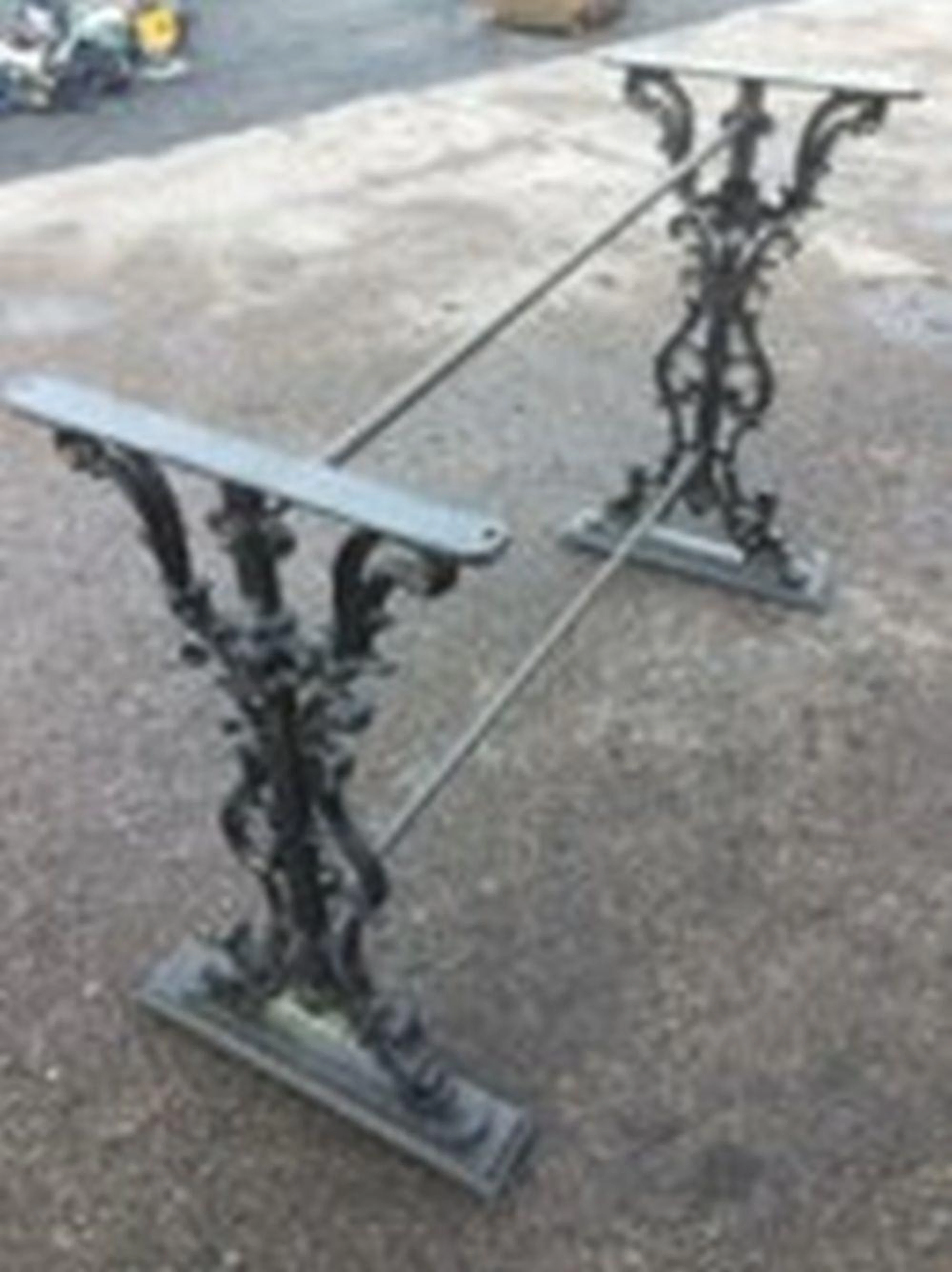 A Victorian cast iron table base with two pierced scrolled supports centeri