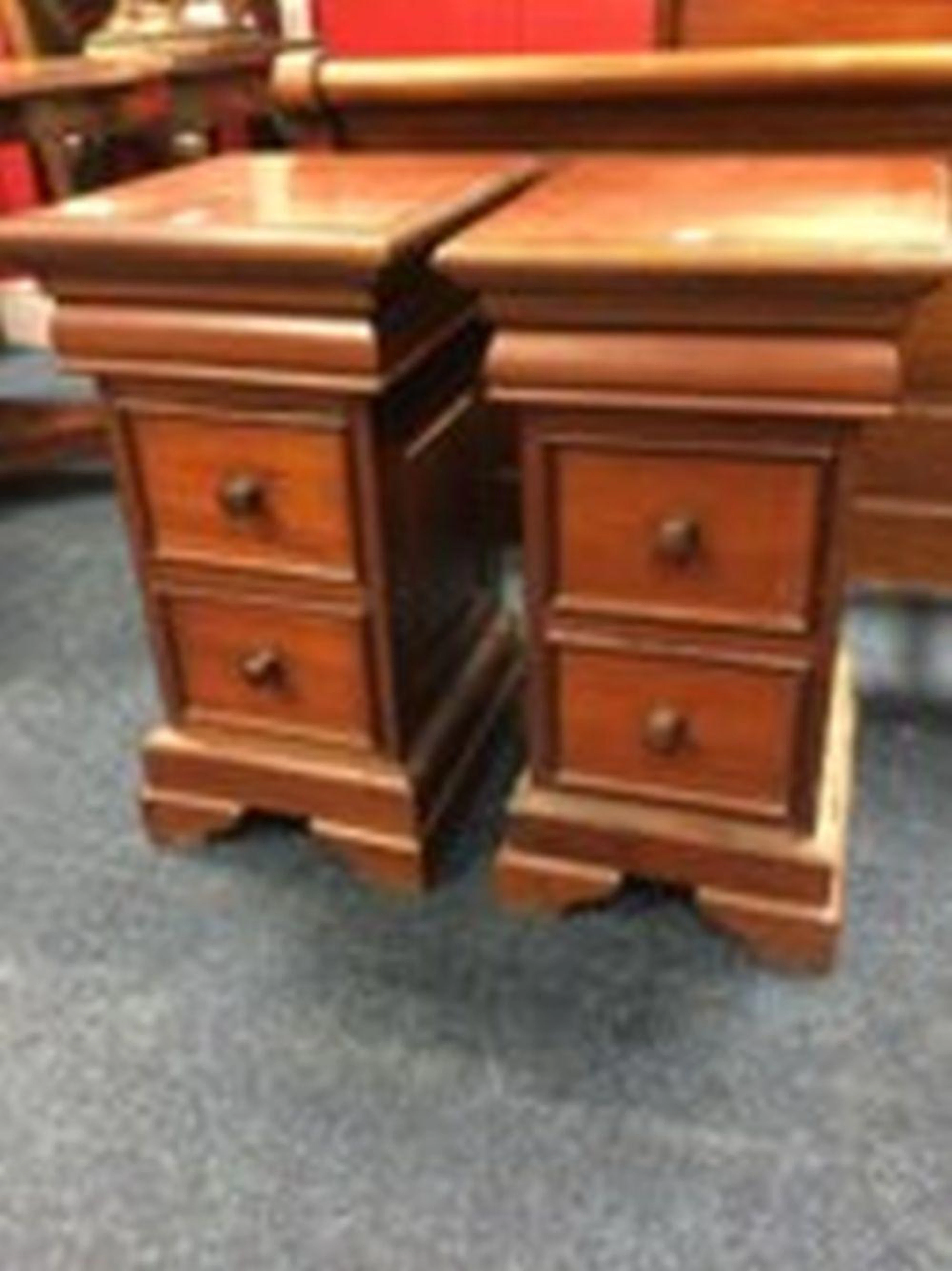 A pair of mahogany bedside cabinets, each with cushion moulded friezes abov