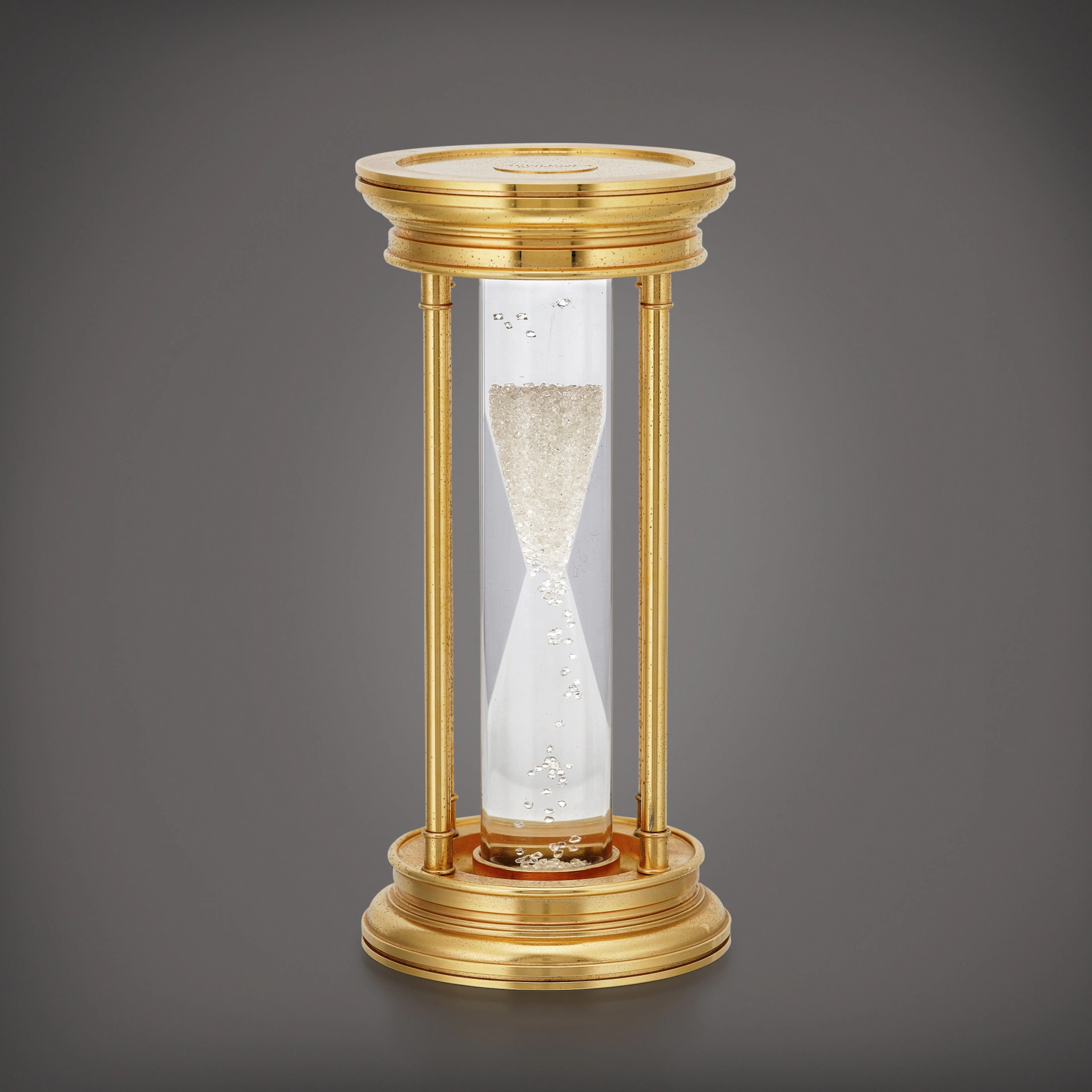 A gilt brass hourglass with floating diamonds