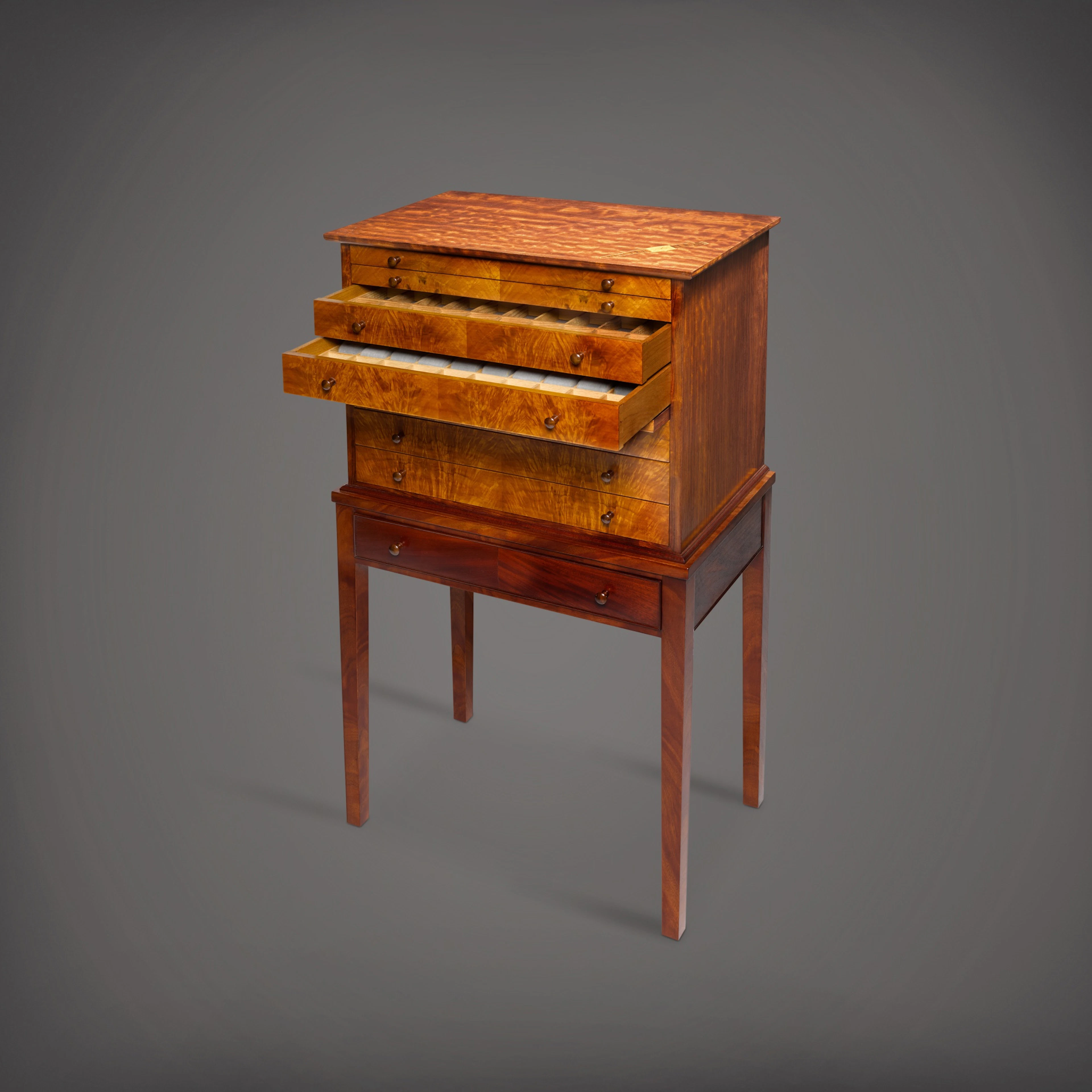 A figured rosewood and mahogany marquetry inlaid watch cabinet on stand