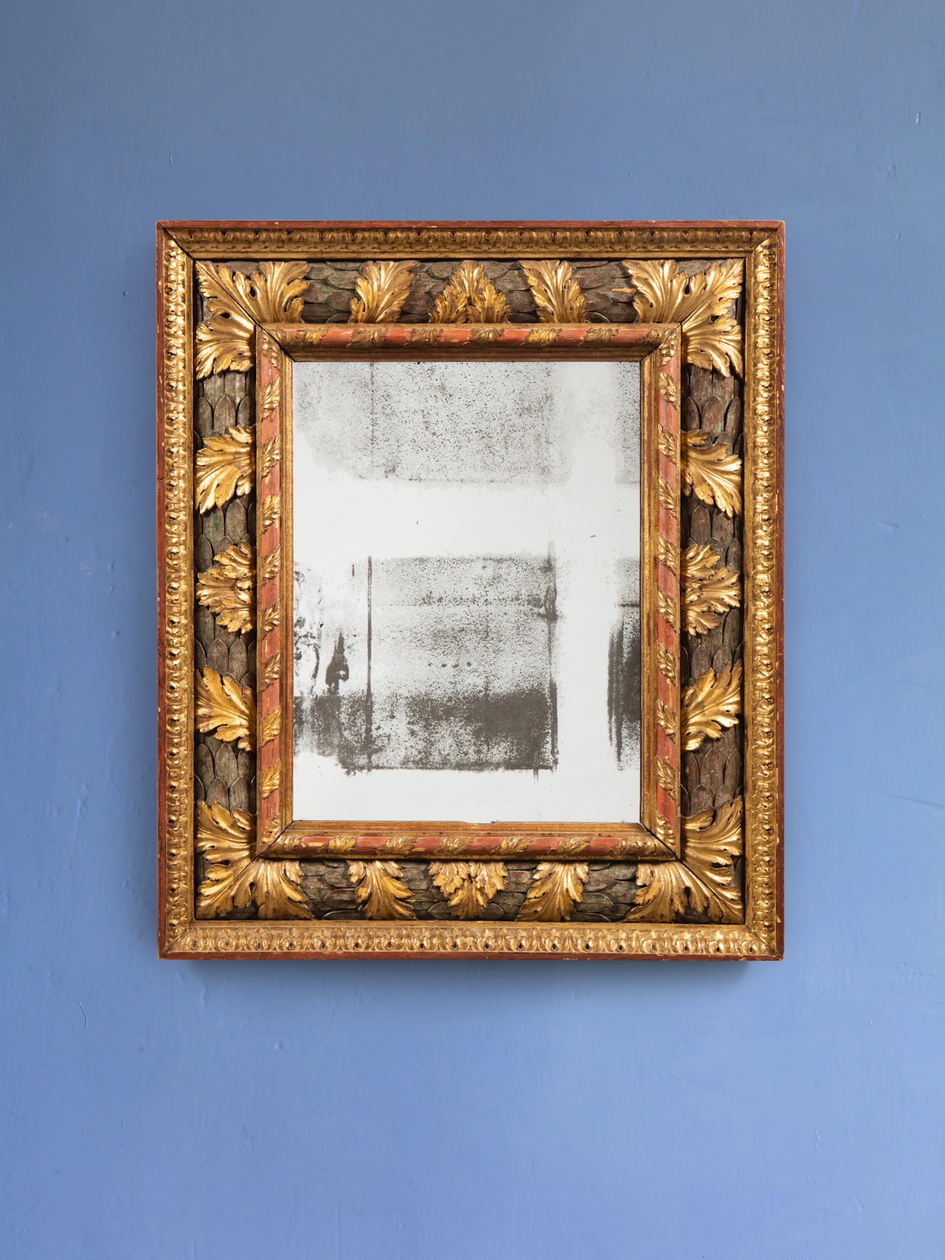 An Italian polychrome giltwood mirrored frame