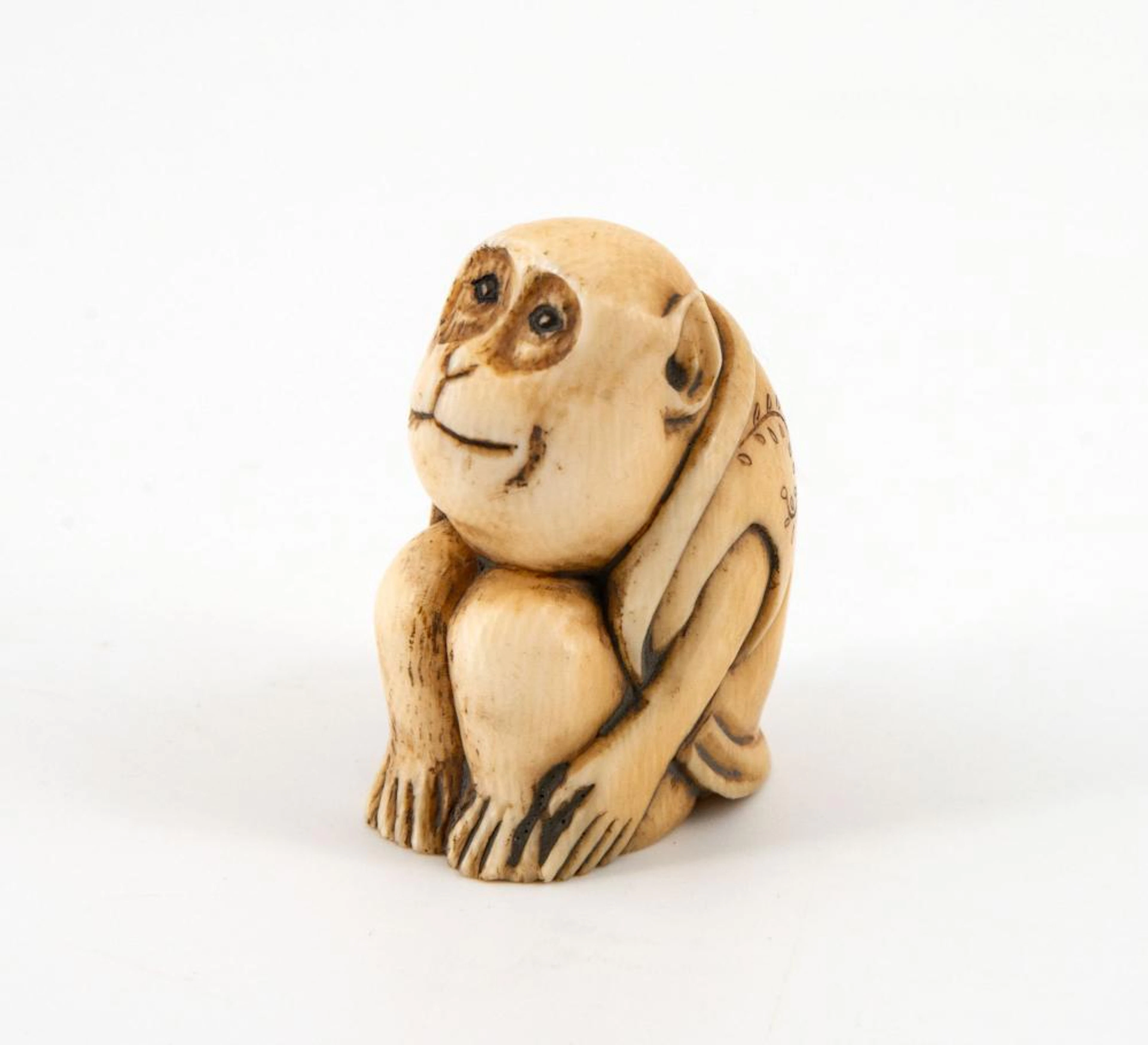 A CARVED KATABORI NETSUKE IN THE FORM OF A MONKEY BY TOMOYUKI, JAPAN, CA 1860