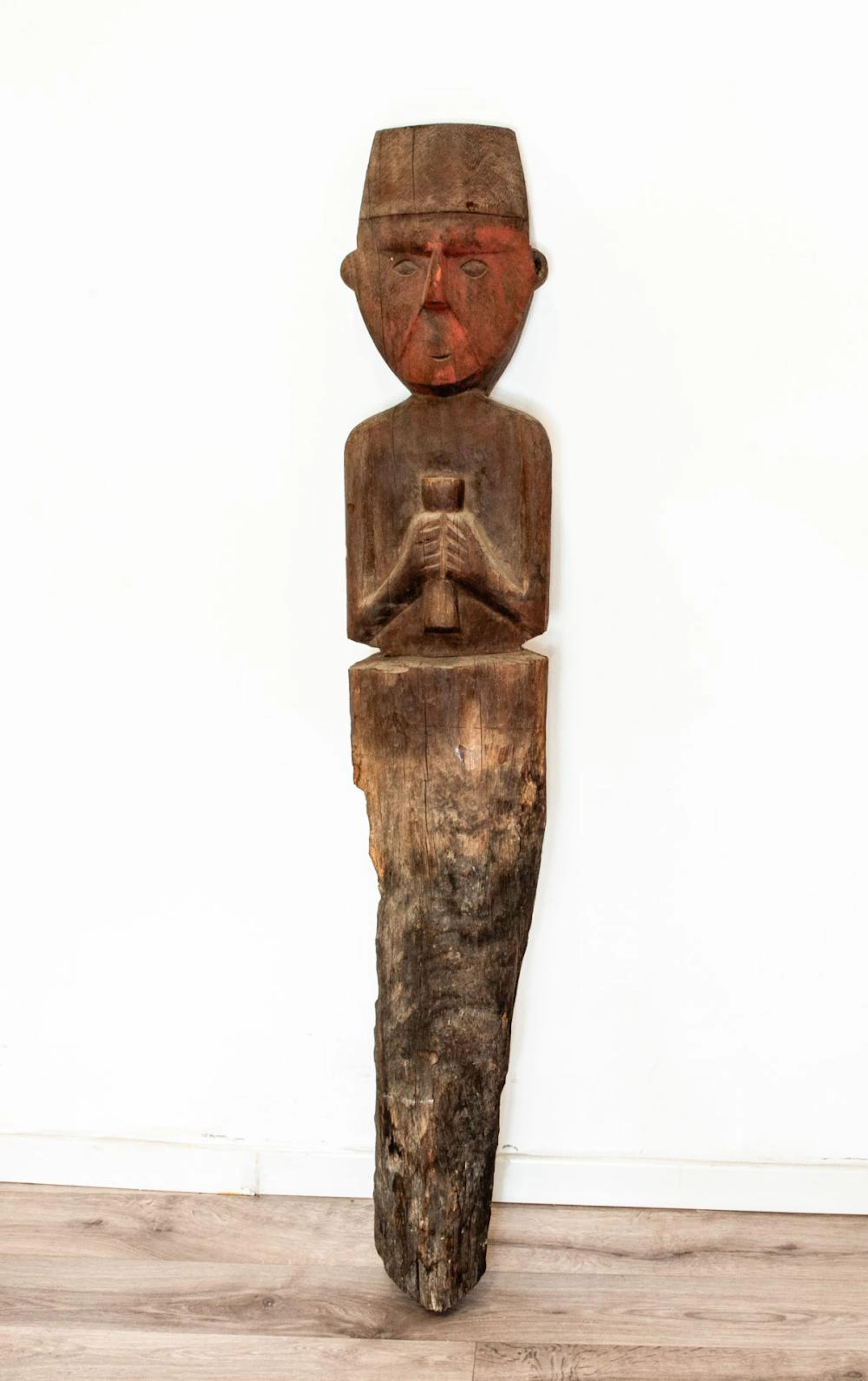 A Ceremonial Wooden Post Showing a Standing Male Holding a Cup