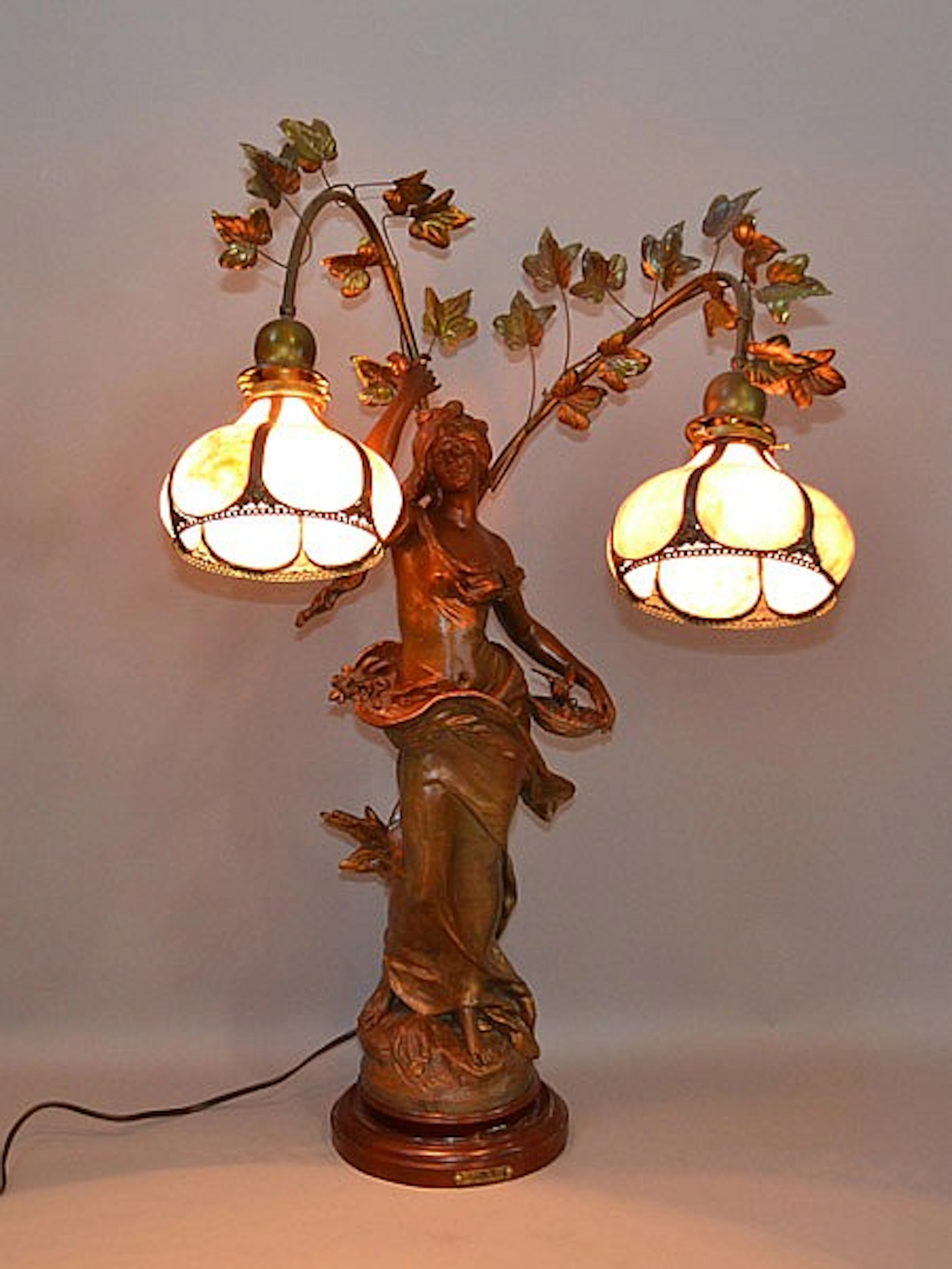 FLEUR DE MAL FIGURAL LAMP BY AUGUST MOREAU Patinated pot metal figural lamp. 2 arms support pink slag glass shades. Painted metal base. Signed on base of sculpture ''Aug.Moreau'' and French Foundry Me