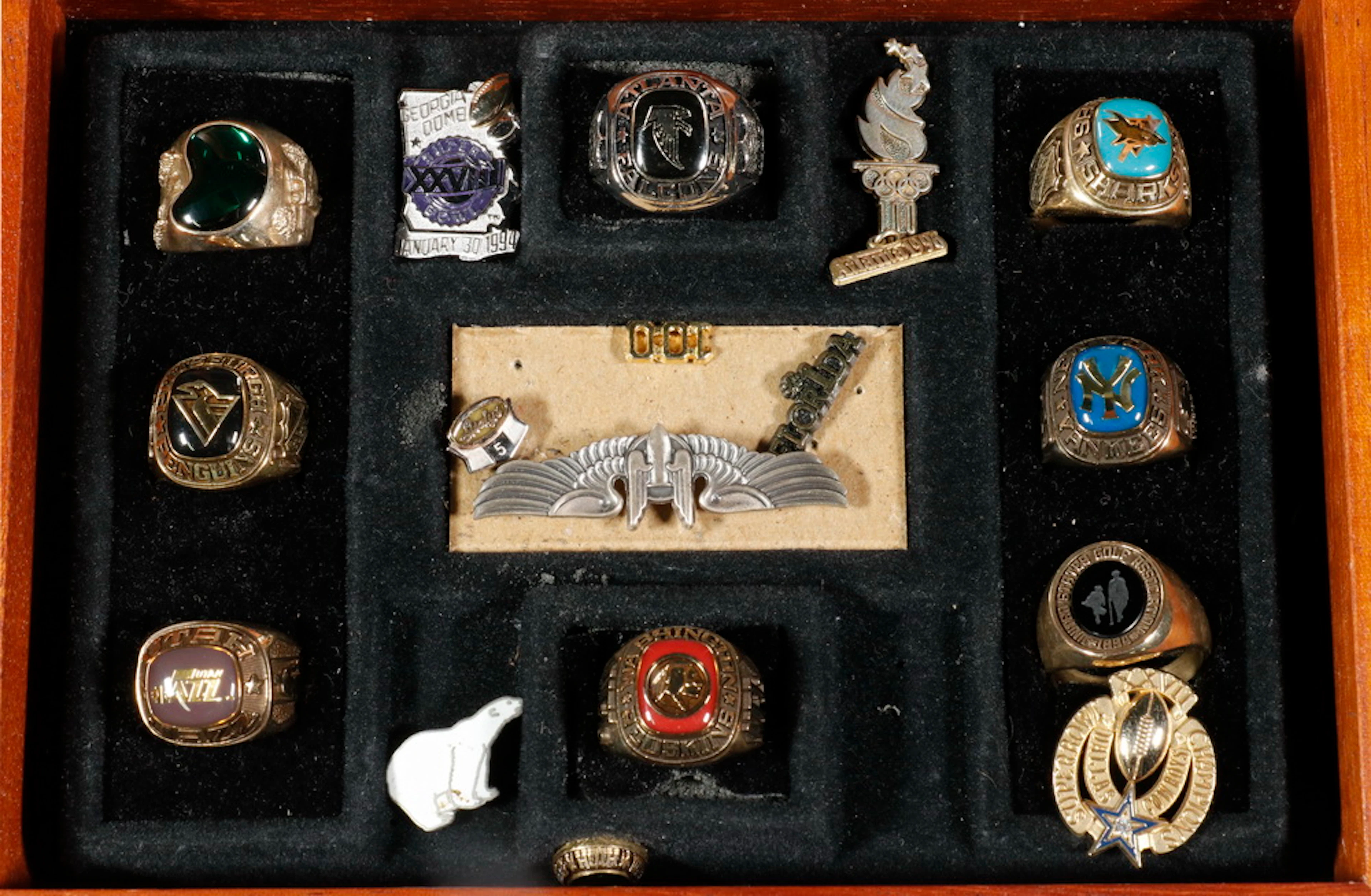 DISPLAY CASE OF (8) RINGS & (8) PINS, MOSTLY SPORTS BY BALFOUR