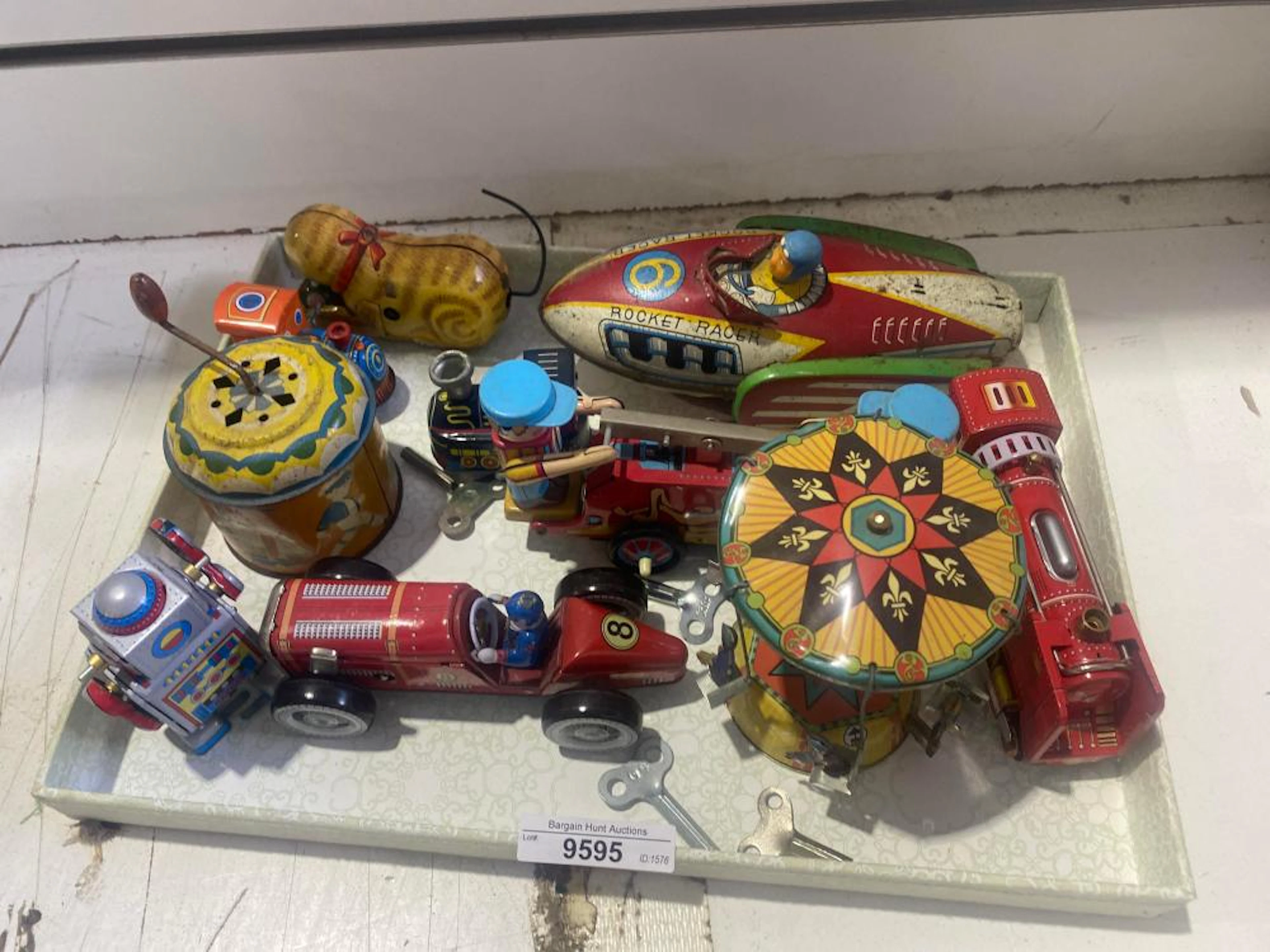 Tin toys, assorted styles, wind up mechanisms. Rocket Racer is 19cm L, 9cm W.