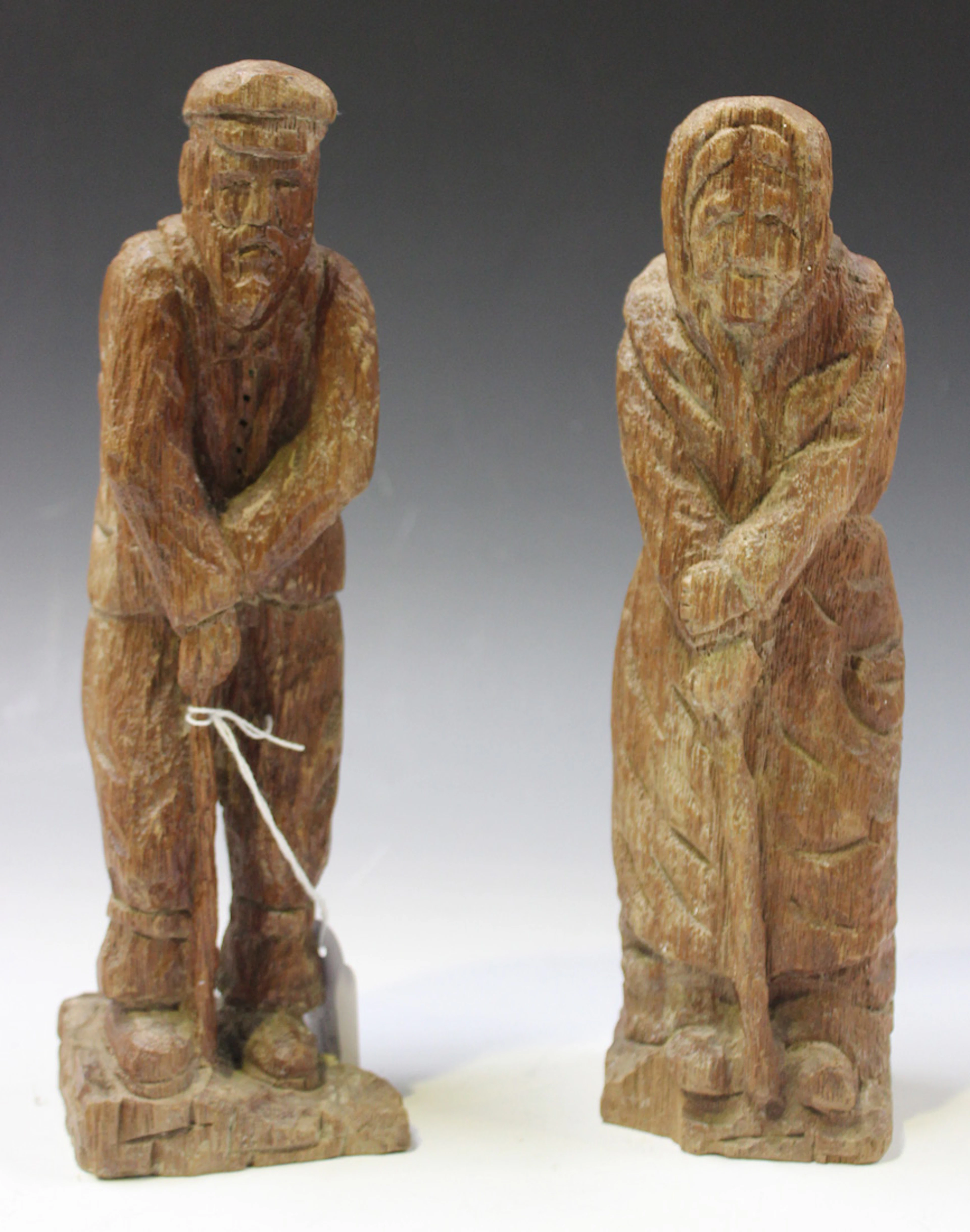 A PAIR OF EARLY 20TH CENTURY CARVED WOOD FOLK ART FIGURES OF AN ELDERLY COUPLE