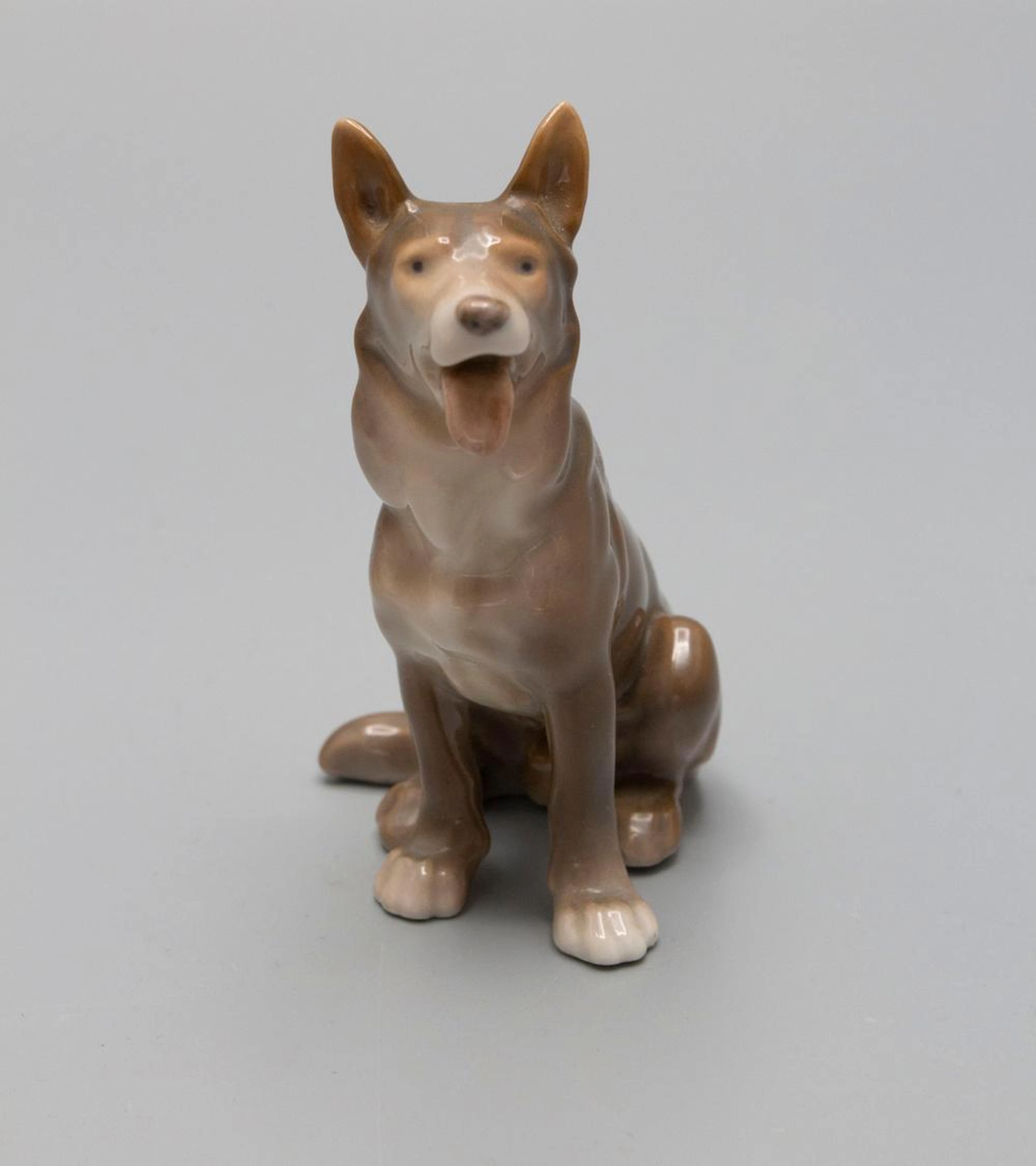 Sitzender Schäferhund / A porcelain figure of a sitting Alsatian German shepherd