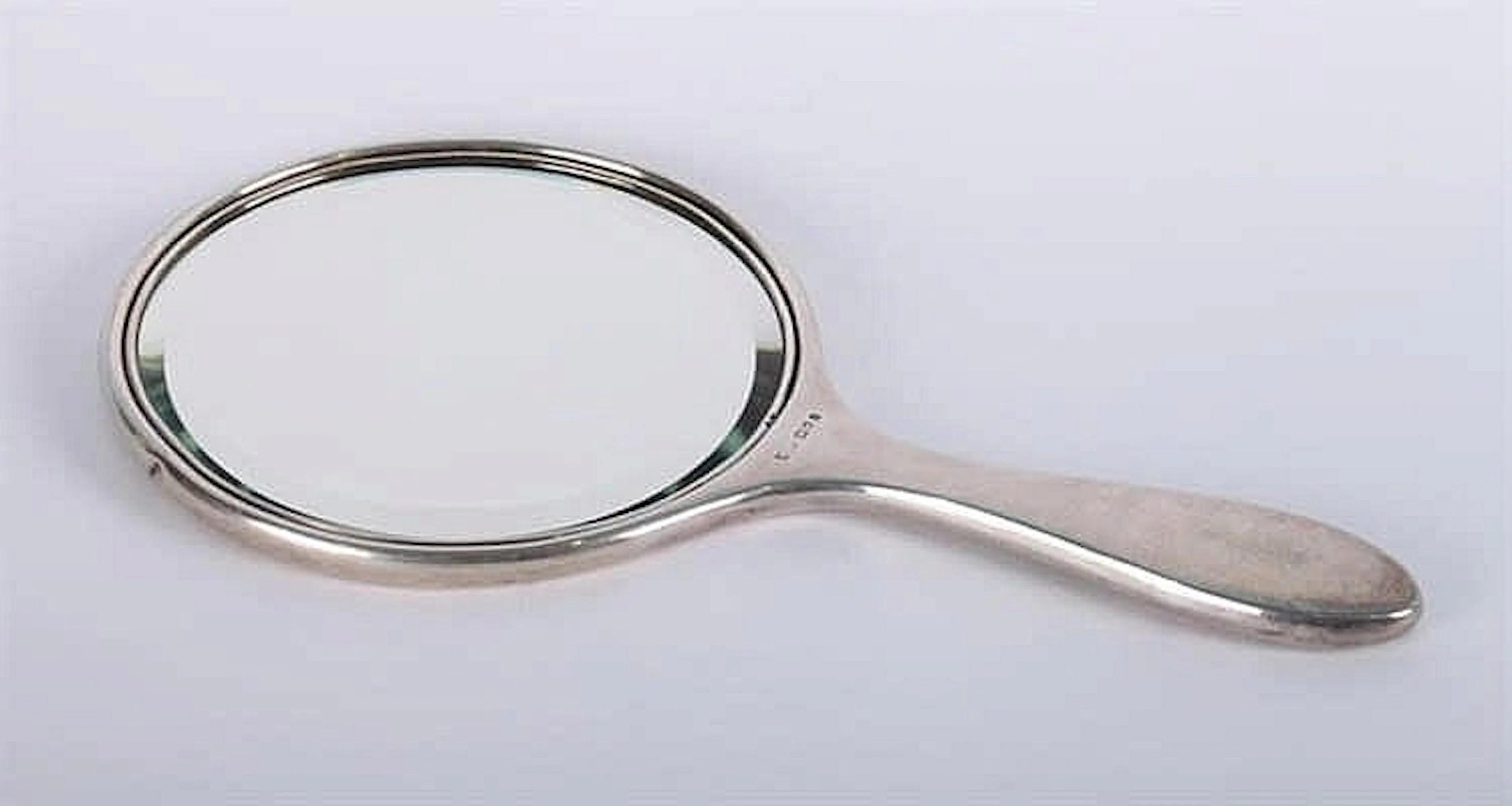 AN ANTIQUE ENGLISH STERLING SILVER HAND MIRROR