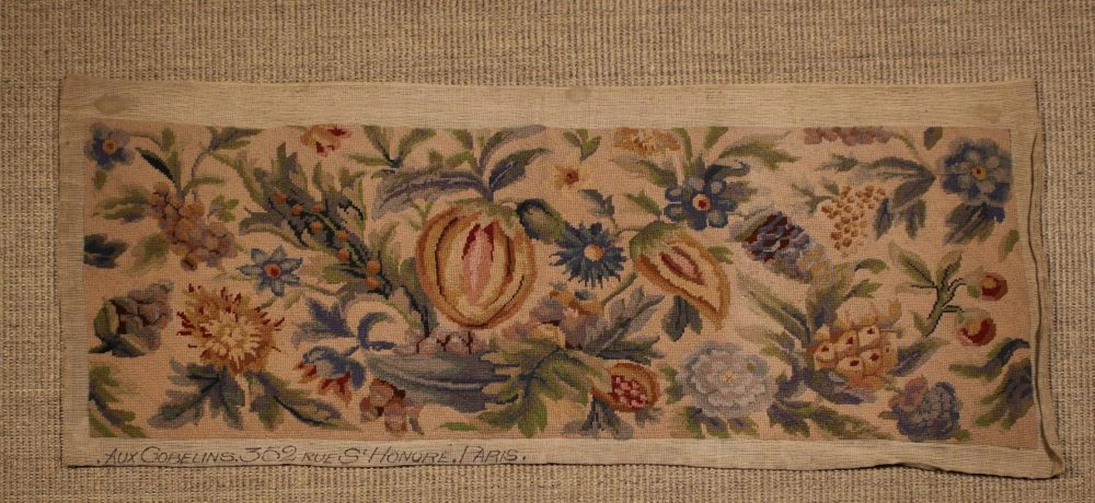 An Unframed Woolwork Panel depicting a display of fruit