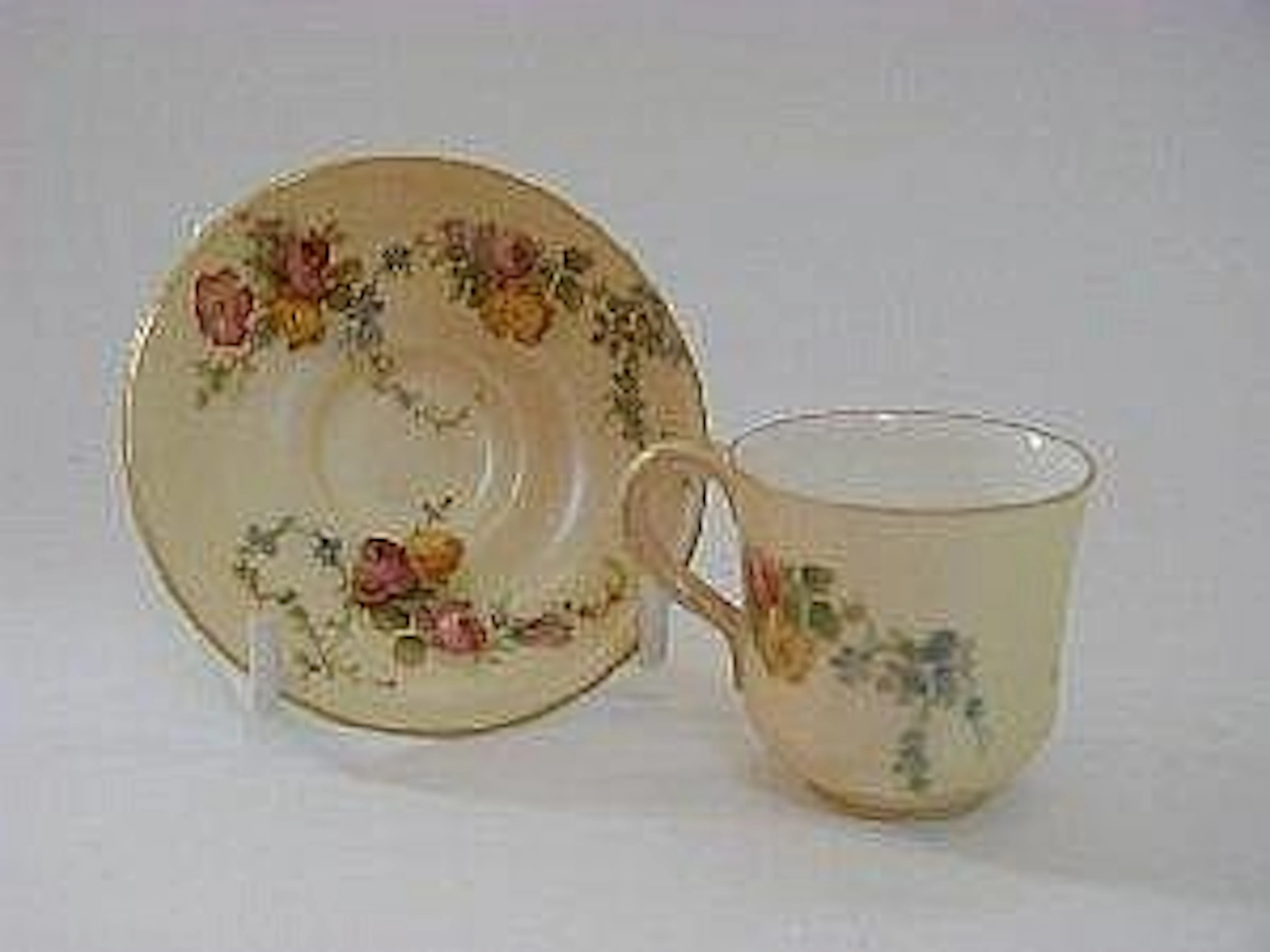 A ROYAL WORCESTER MINIATURE BLUSH IVORY CUP AND SAUCER