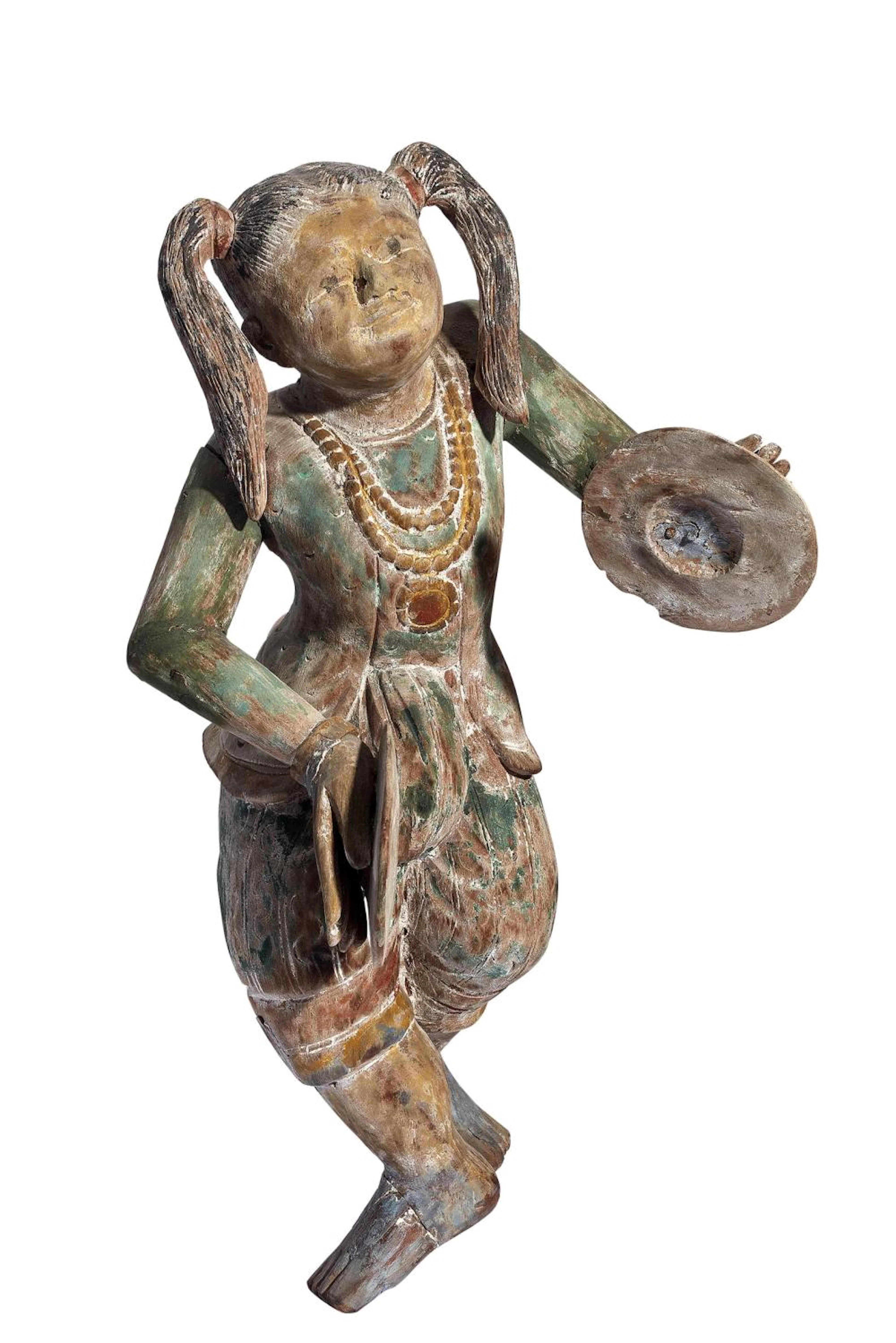 AN ANTIQUE INDIAN POLYCHROME WOOD CARVING OF A FEMALE MUSICIA