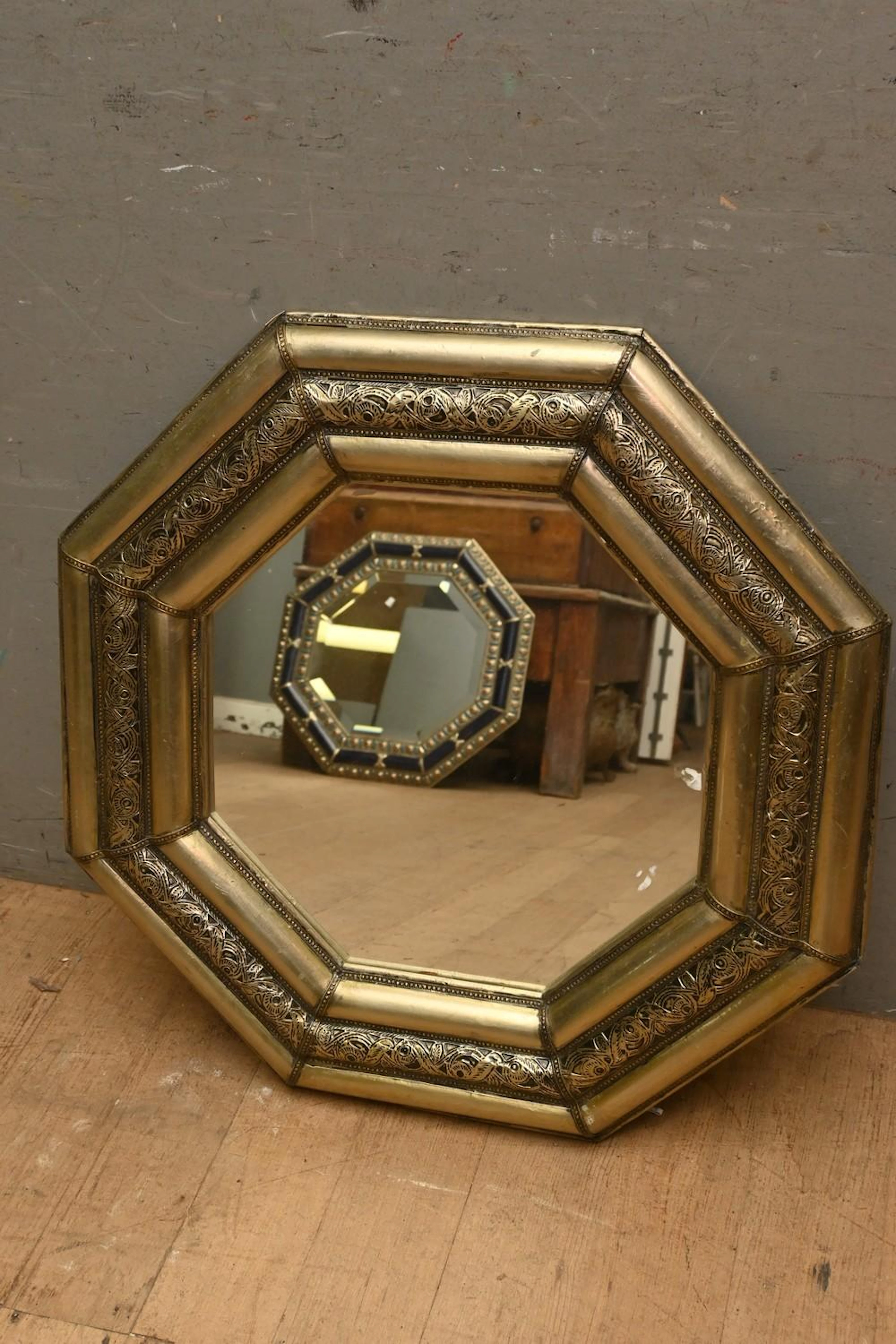 AN OCTAGONAL MOROCCAN PRESSED METAL MIRROR ( 67H X 67W...