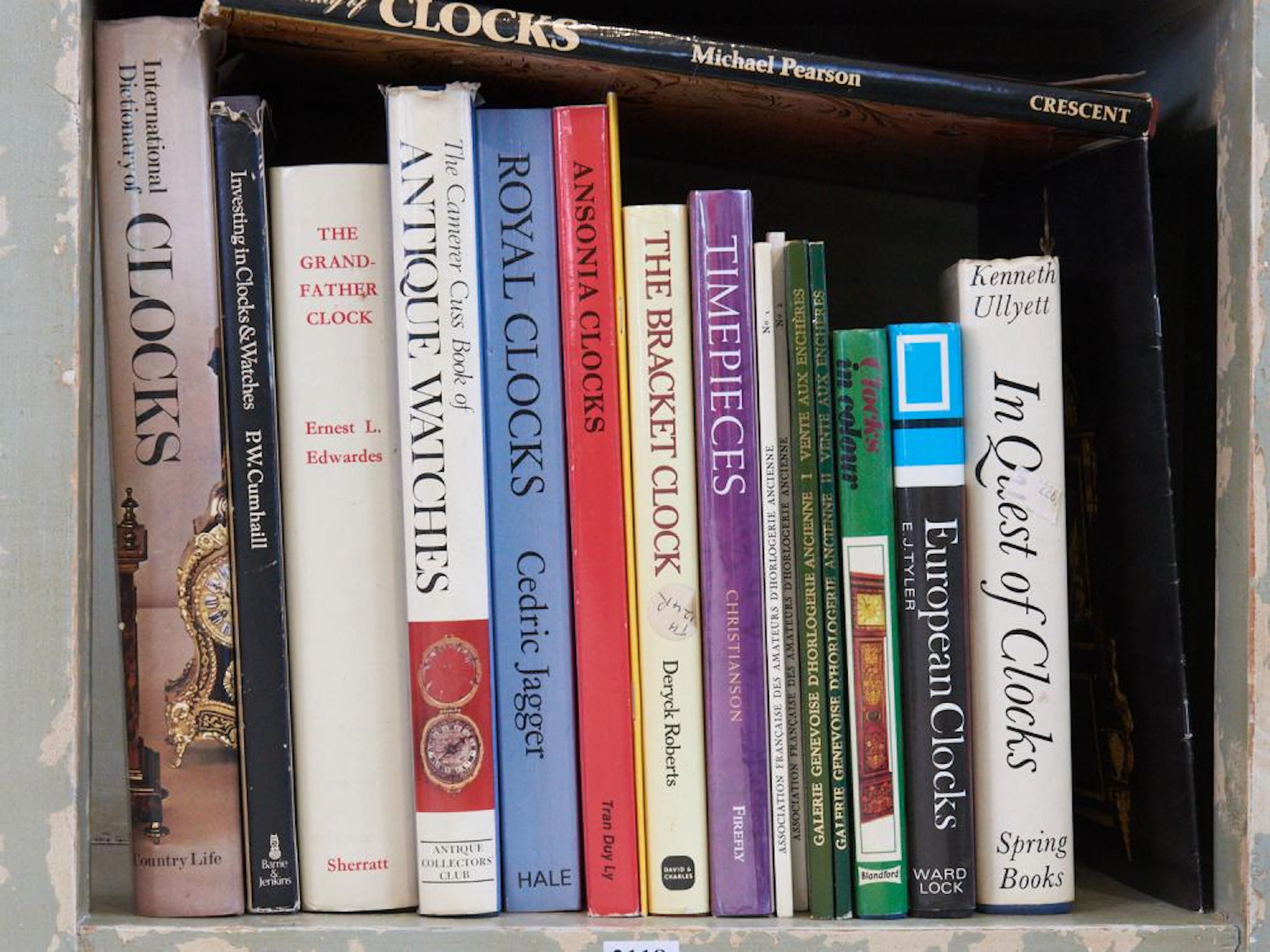 A SHELF OF REFERENCE BOOKS ON HOROLOGY INCLUDING ROYAL CLOCKS