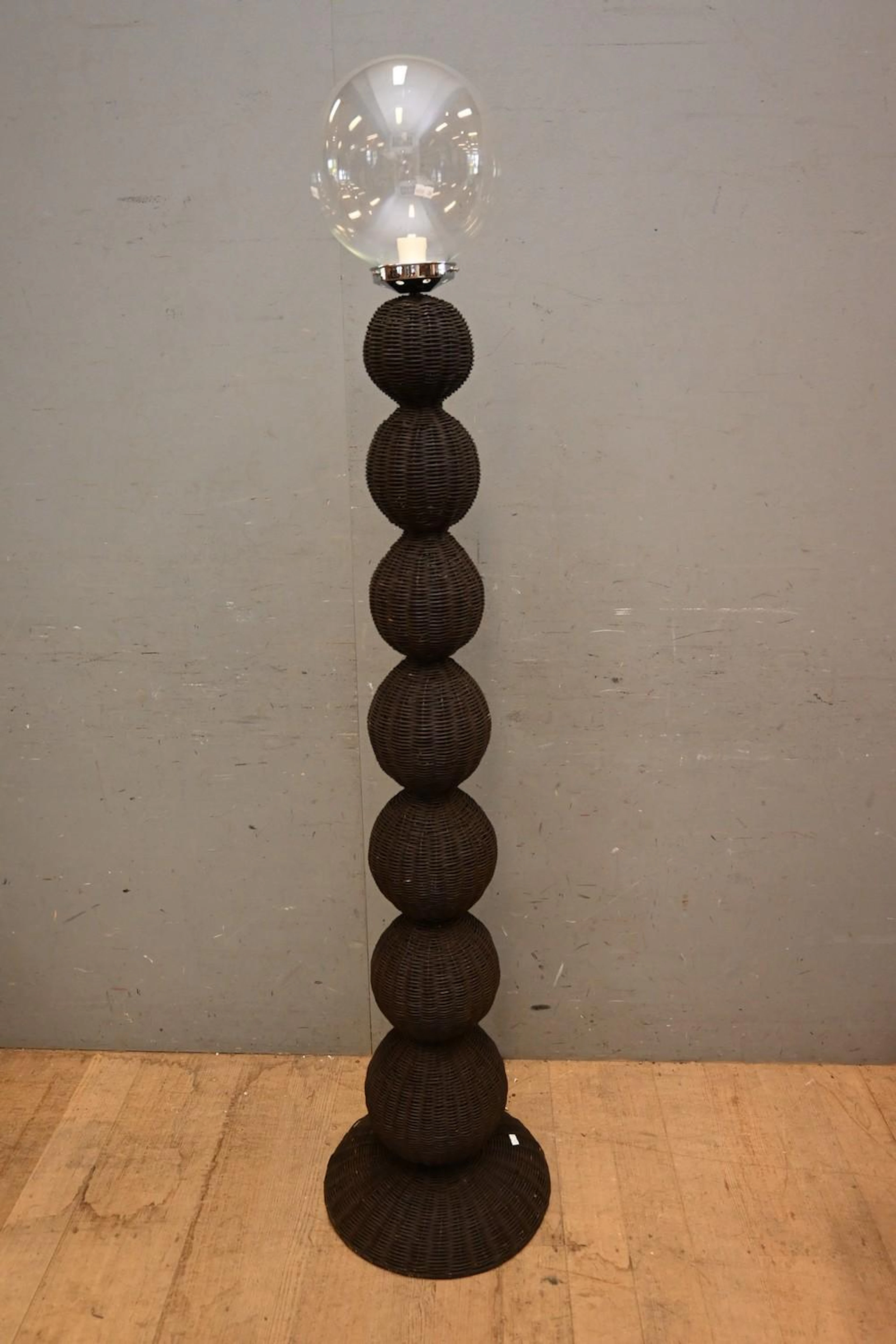A GREY WOVEN CANE STANDARD LAMP WITH CLEAR GLASS BALL...