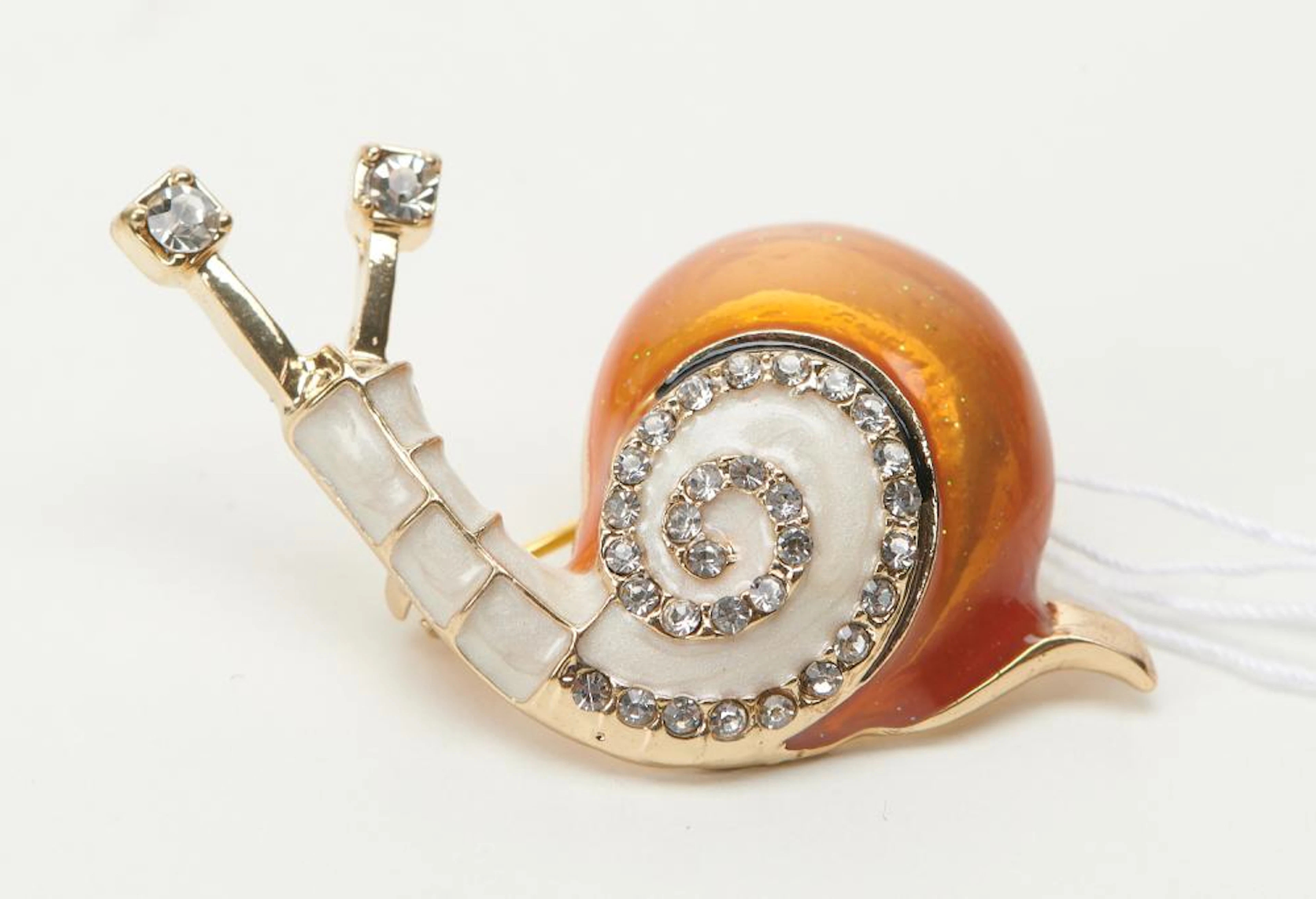 AN ENAMELLED AND RHINESTONE SET SNAIL BROOCH