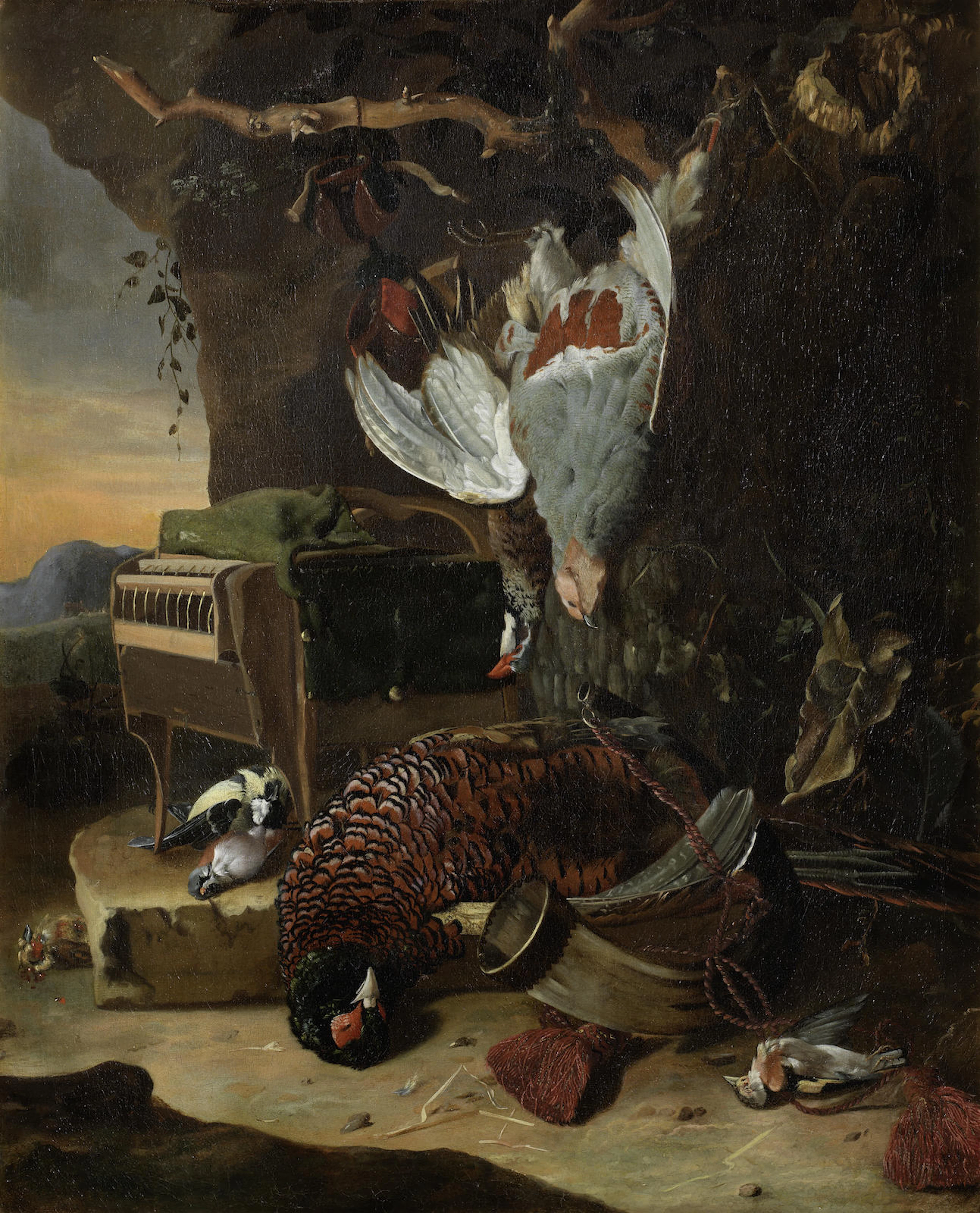 A dead pheasant with dead song birds at the foot of a tree surrounded by hunting paraphernalia