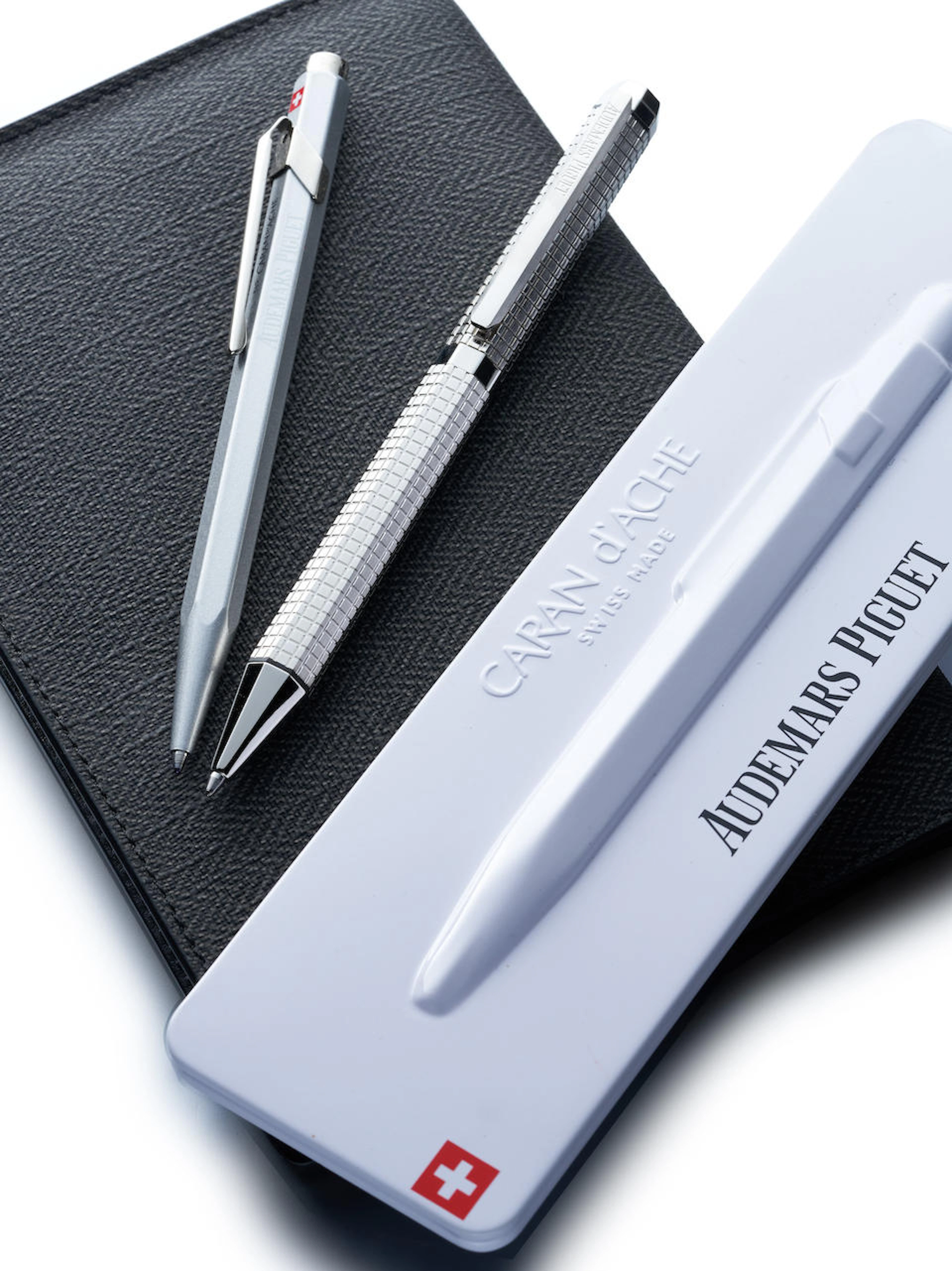 AUDEMARS PIGUET | GROUP OF THREE: A LEATHER WALLET AND TWO BALLPOINT PENS